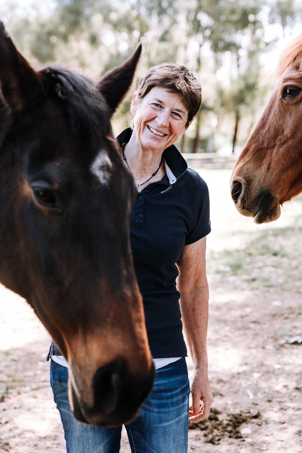 Jenny McKenzie, Reiki Master and nature-based practitioner, with horses in Beechworth.