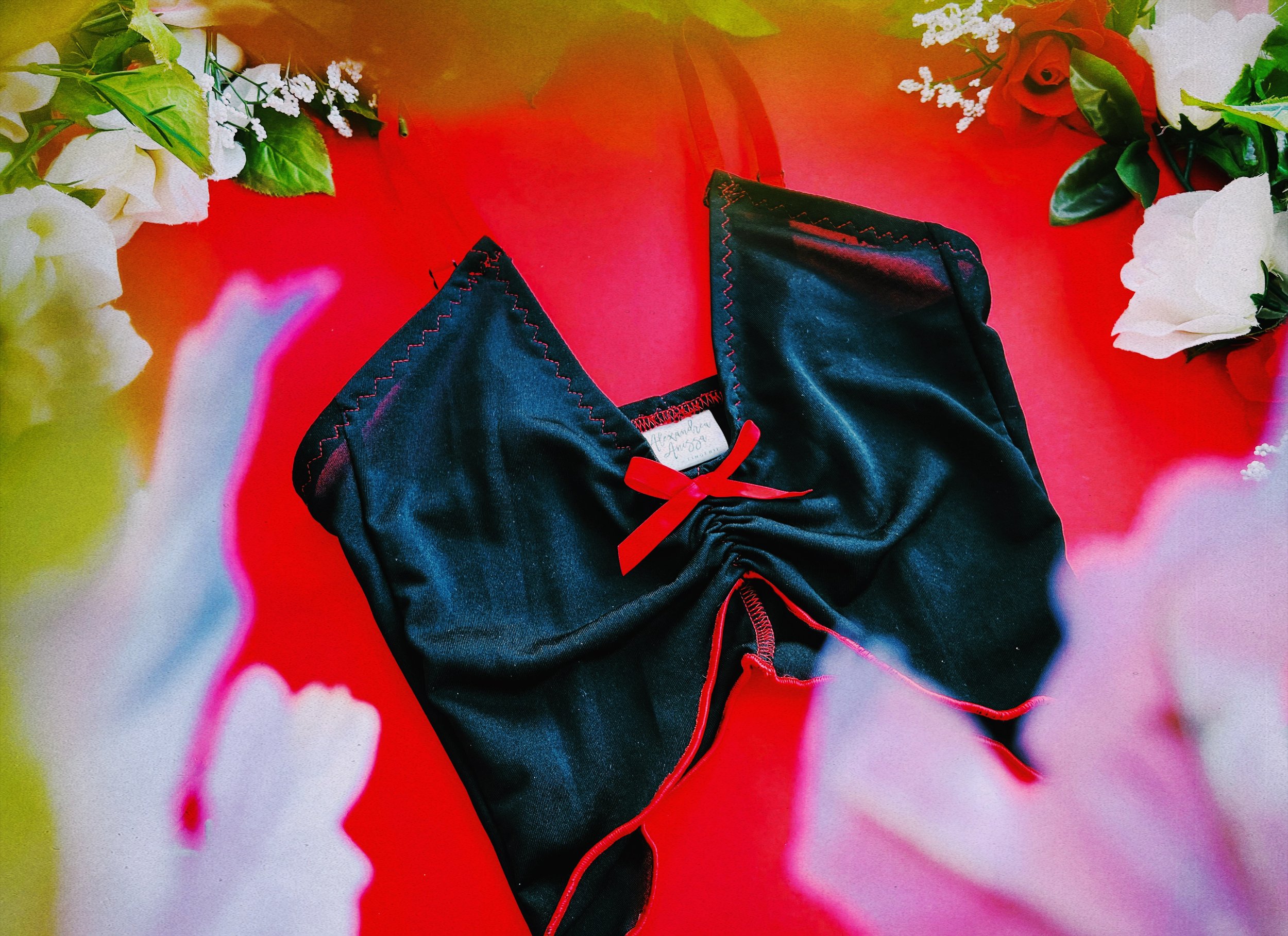 A side view showcasing the black mesh fabric and red stitching of the lingerie top, highlighting the attention to detail.