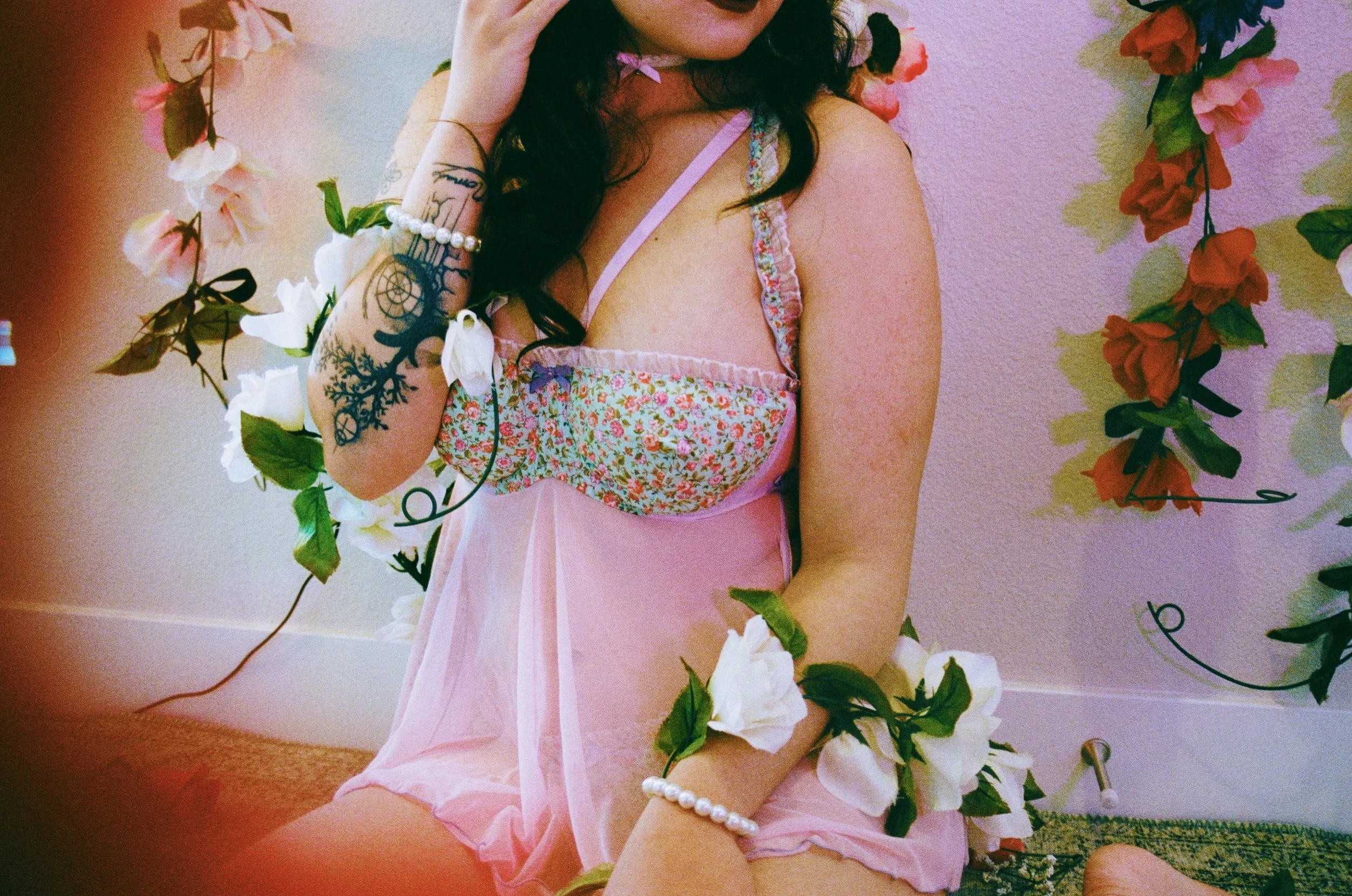 Close-up of woman adjusting lingerie strap, soft vintage-style lighting.