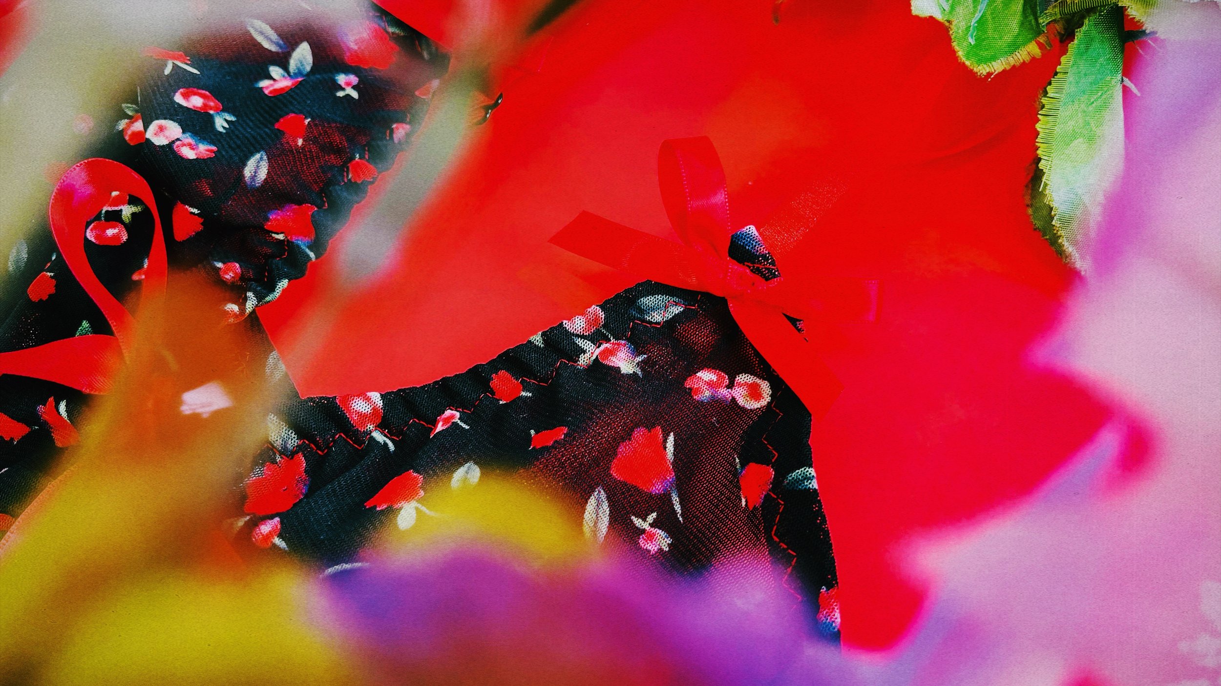 A romantic display of the floral lingerie with red ribbon accents, surrounded by a soft focus of colorful flowers.