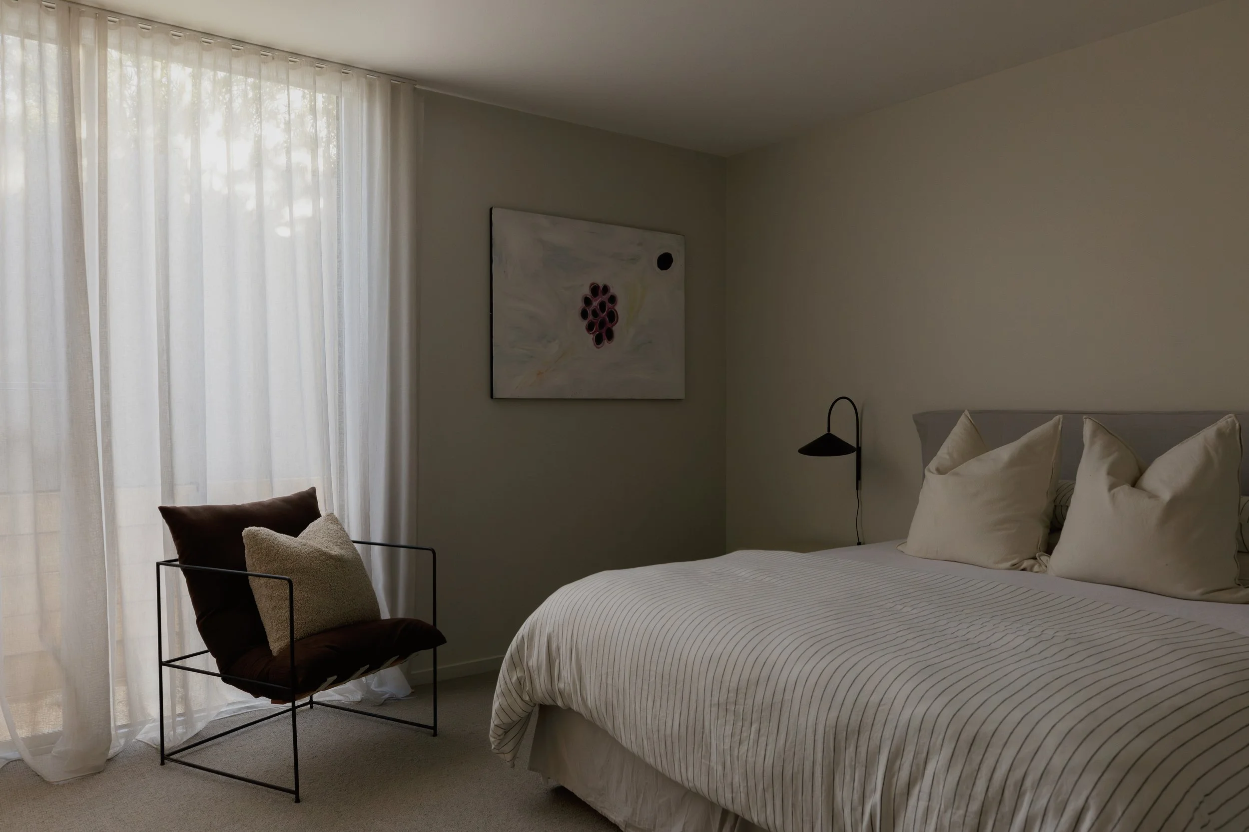 Build by Rawlinson, architecture by Pleaser Perkins. Master Bedroom. Striped bedsheets, iron chair, grapevine artwork, sheer curtains.