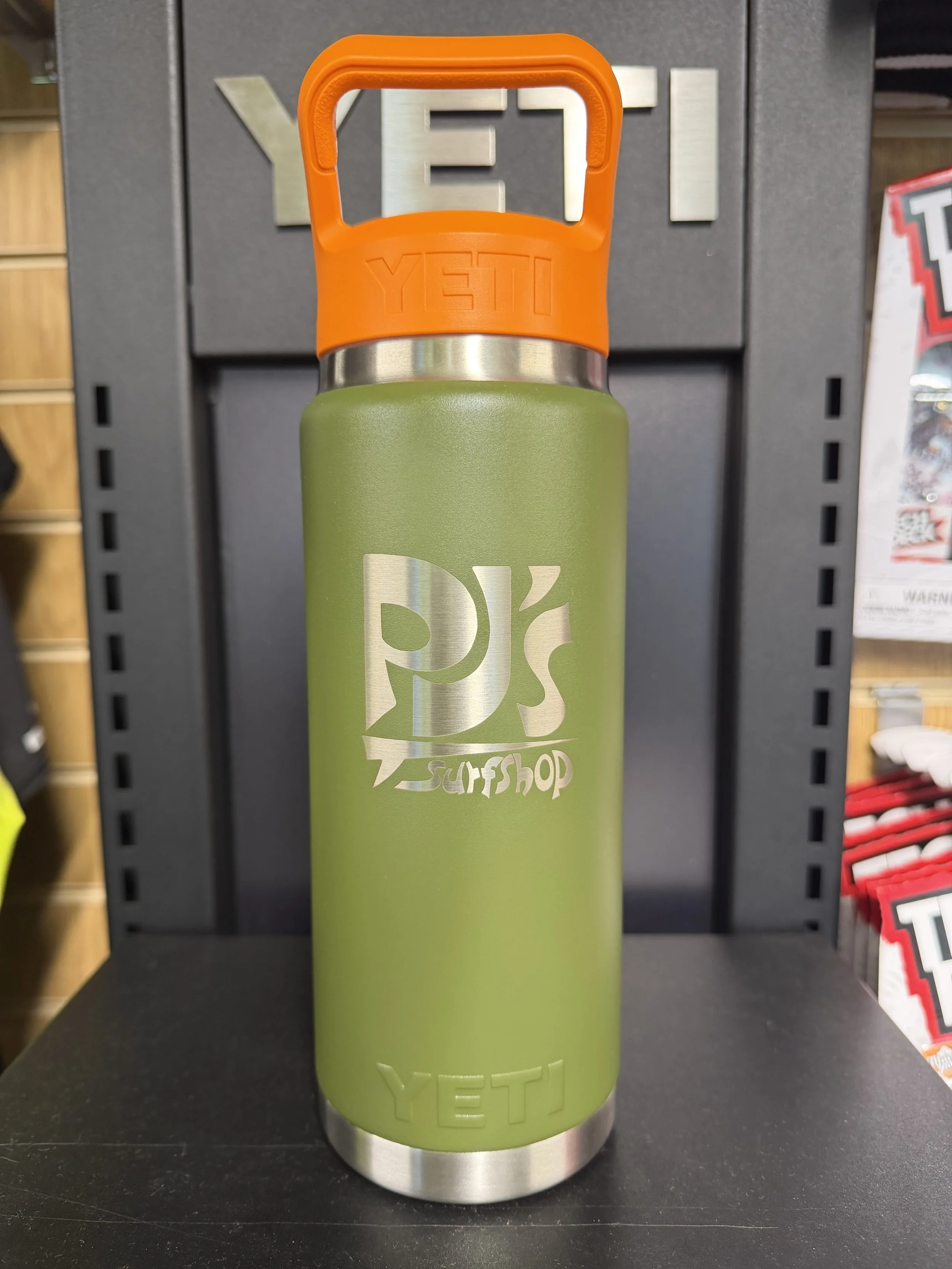 PJ’s Surf Shop logo on an olive YETI Rambler 26oz bottle with orange Straw Cap