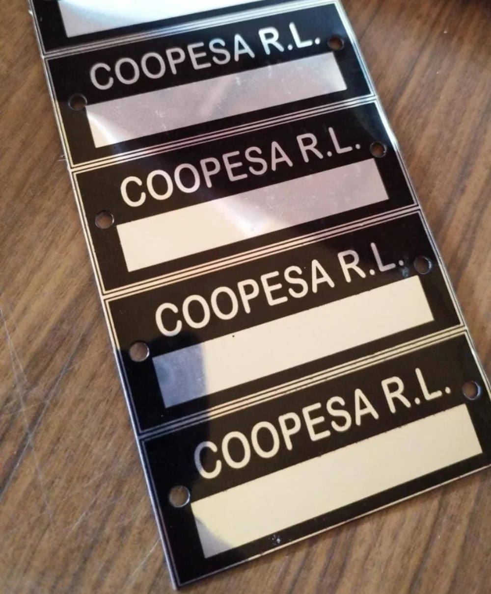 Placas de aluminio negro con el nombre de Coopesa