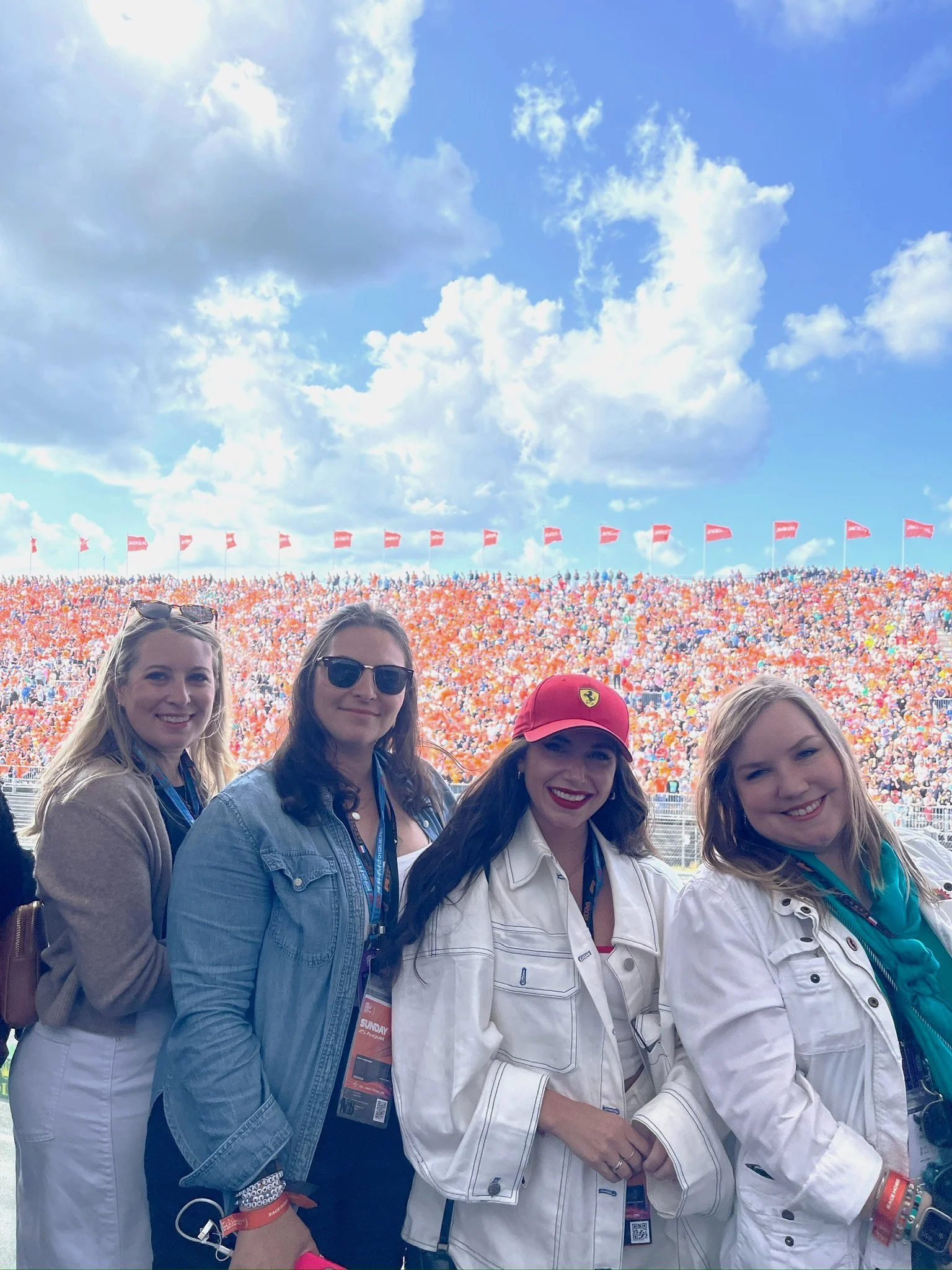 Group of OTTR guests smiling together in the grandstand at a Formula 1 race