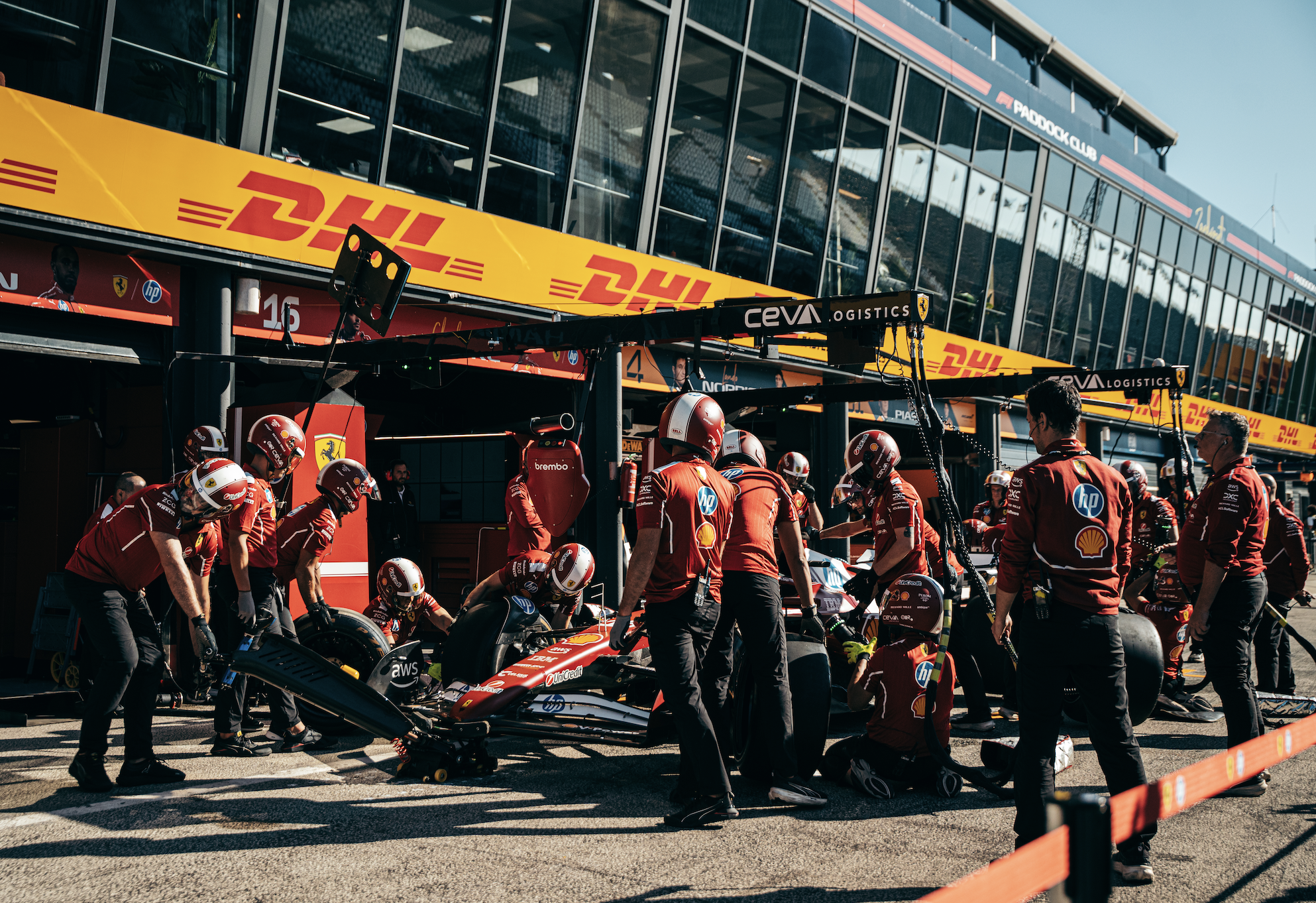 Ferrari Formula 1 crew practicing a pit stop with mechanics changing tires during a Grand Prix race weekend