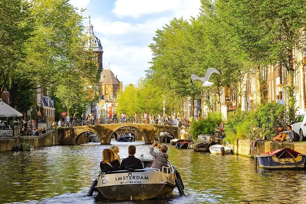 Classic Amsterdam canal scene with historic canal houses and bicycles along a bridge railing