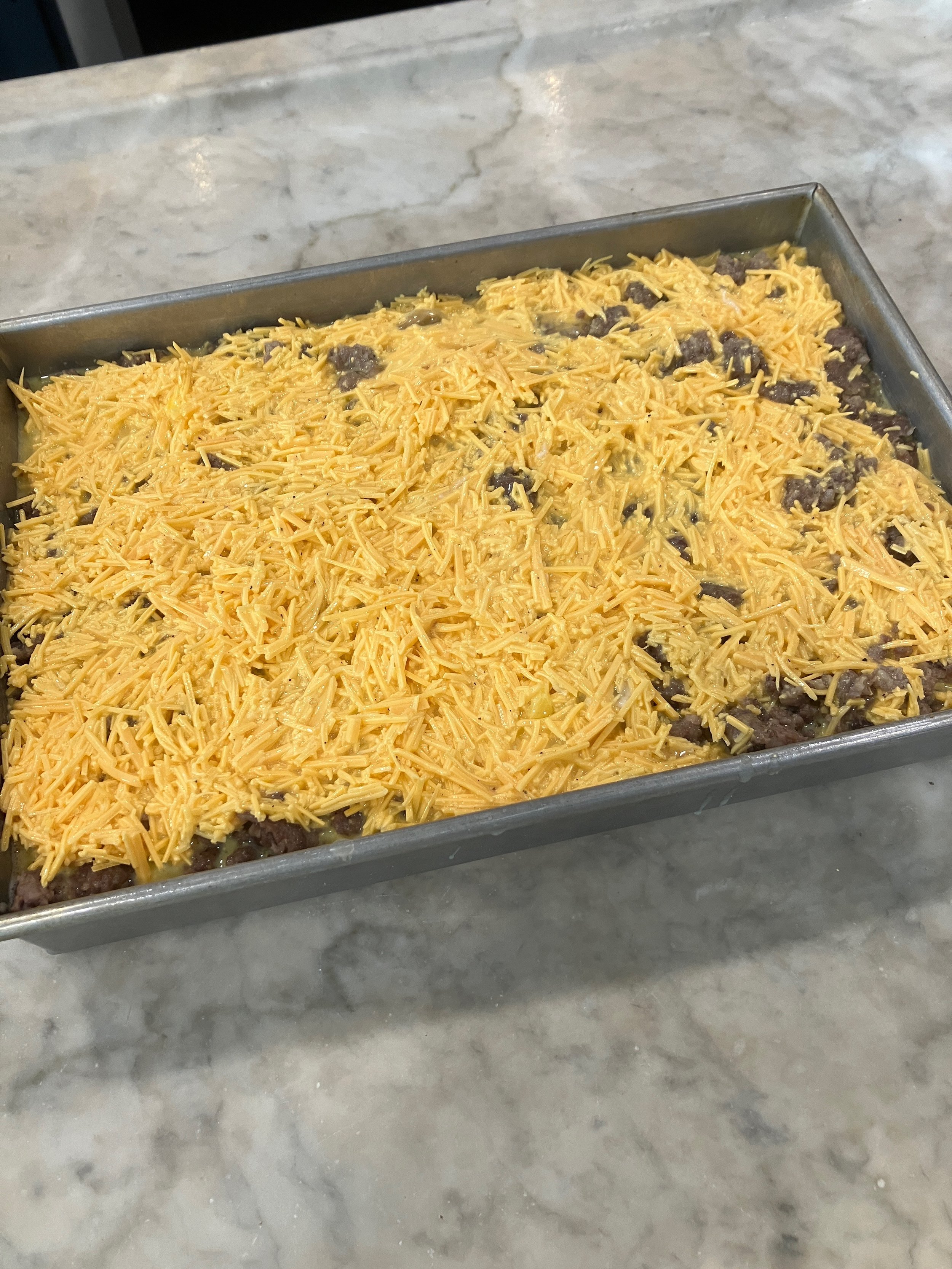 Sausage, leek and hash brown casserole in baking dish before baking
