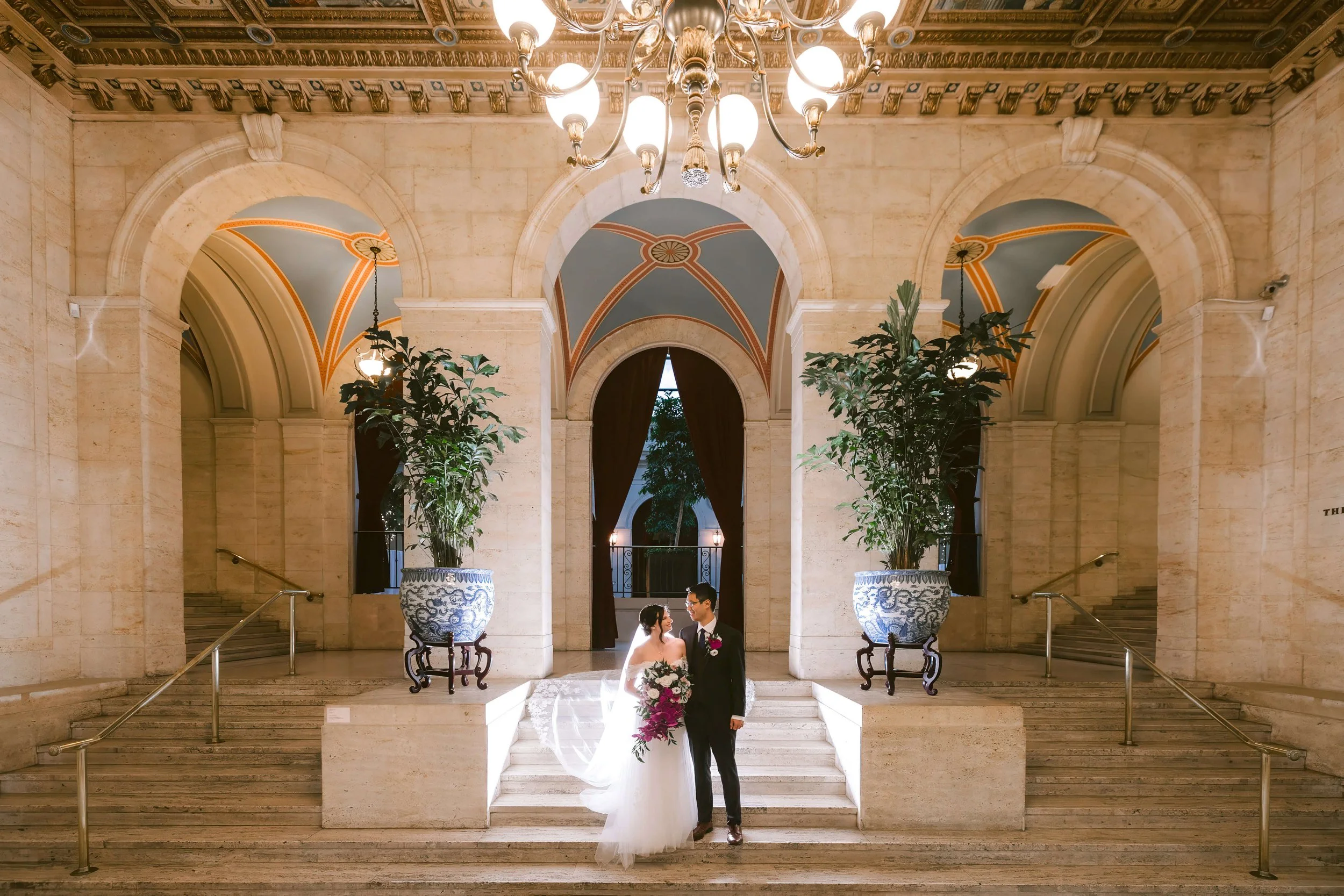 Bride and groom on the staircase landing of the McCoy Family Broad Street Lobby at the Columbus Museum of Art
