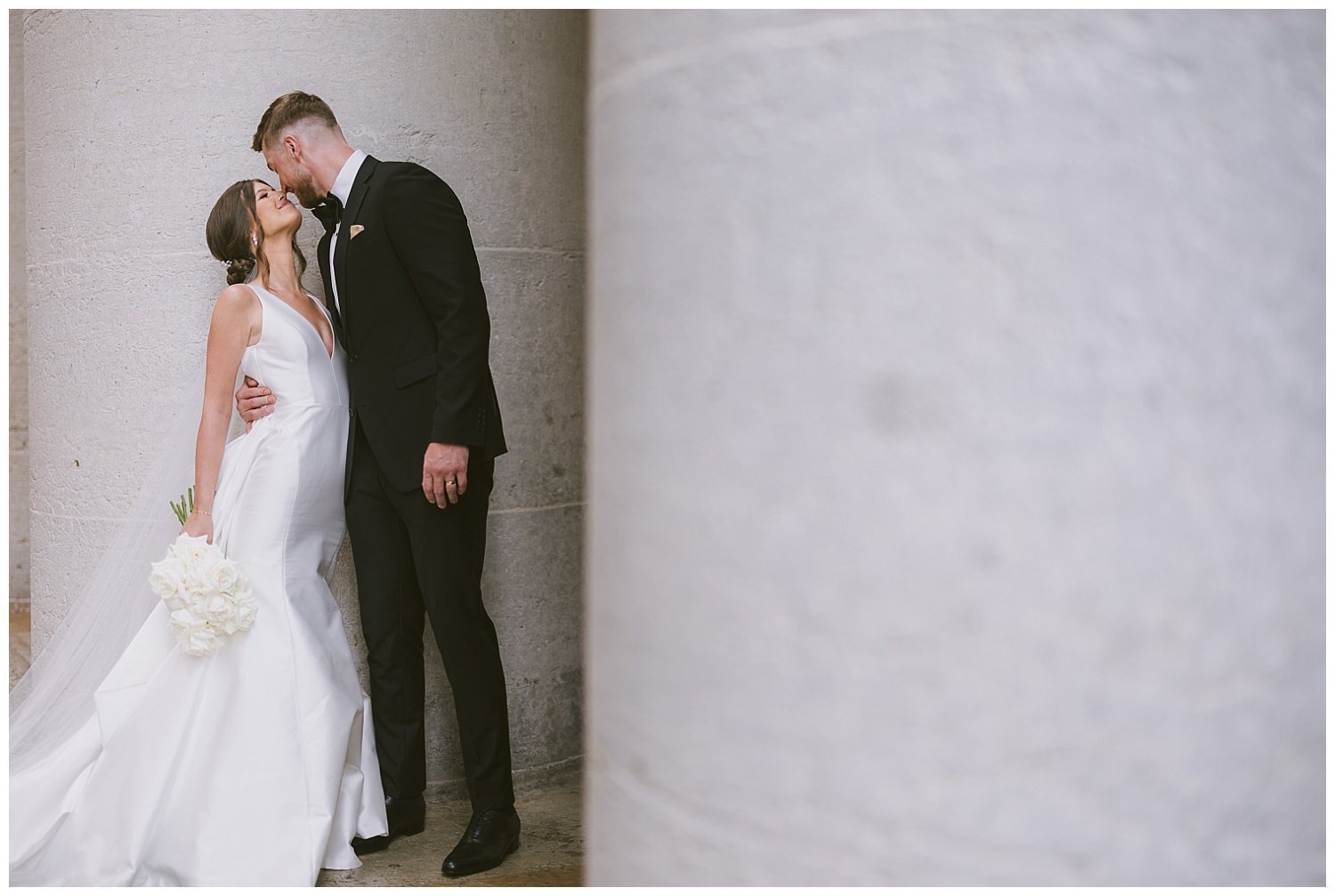 A bride and groom sharing an embrace at the Ohio Statehouse. 