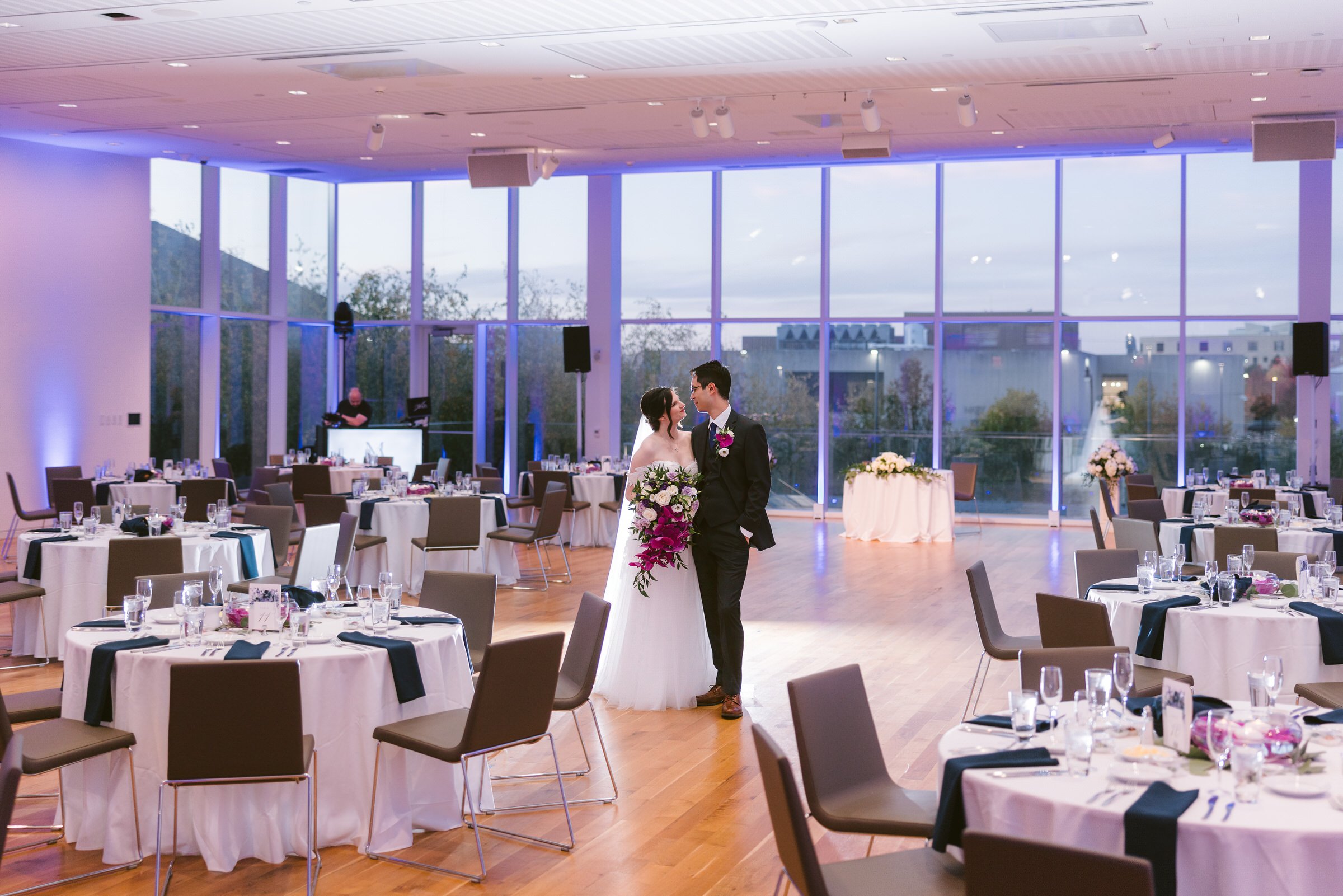 Wedding reception in the Schottenstein Property Group Pavilion at the Columbus Museum of Art, with purple uplighting and floor-to-ceiling windows