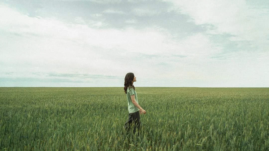 woman walks through field