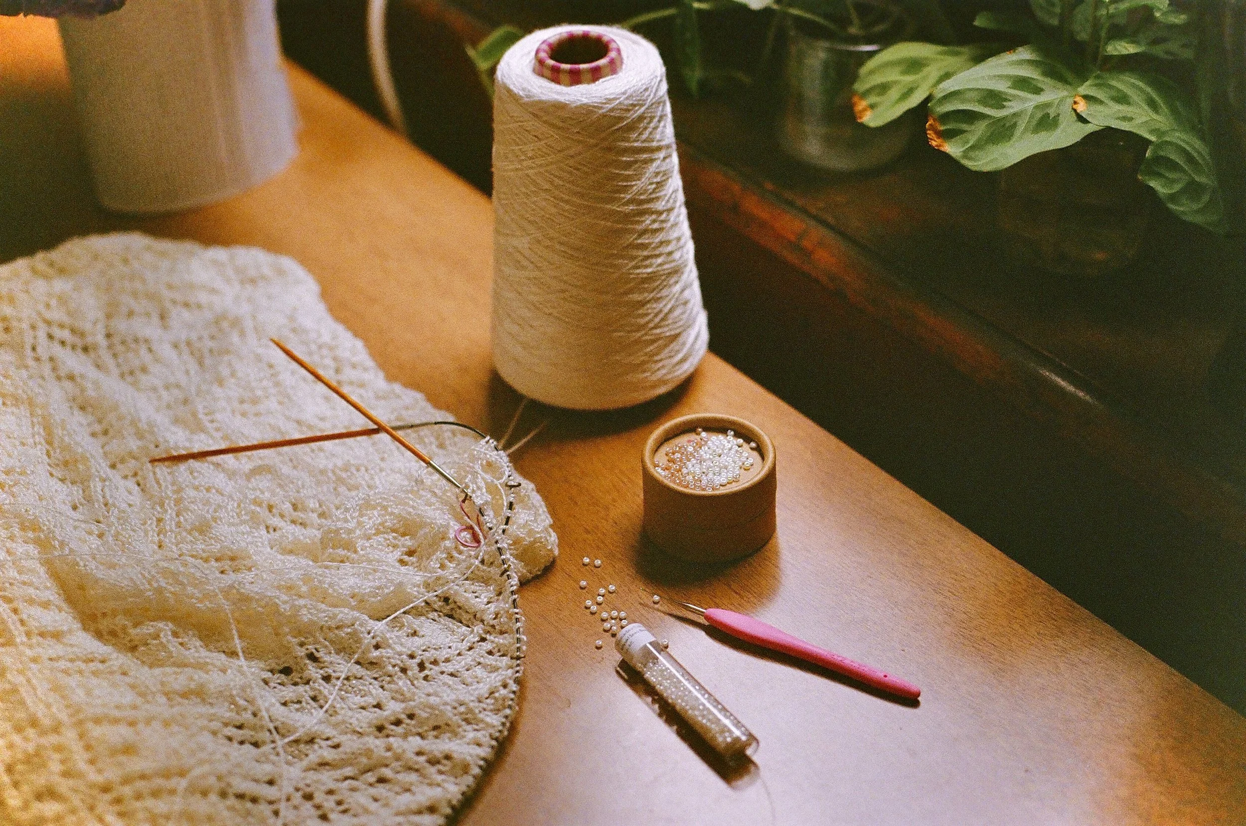 Applying the different colored beads throughout the lace design with a 0.6mm crochet hook. Since I increased the bead placement compared to what the pattern called for, there are over 2,500 beads in the dress!