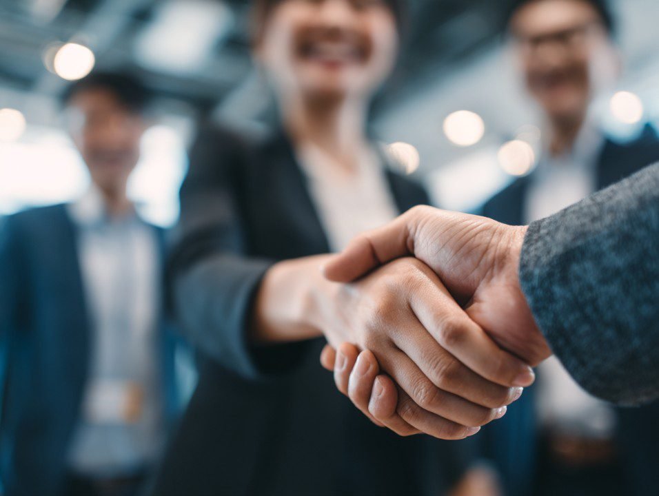 Business professionals shaking hands, representing sponsorship and partnership support that enables organisations like imabi and imabi Community CIC to expand access to safety, safeguarding and wellbeing technology across schools and communities.