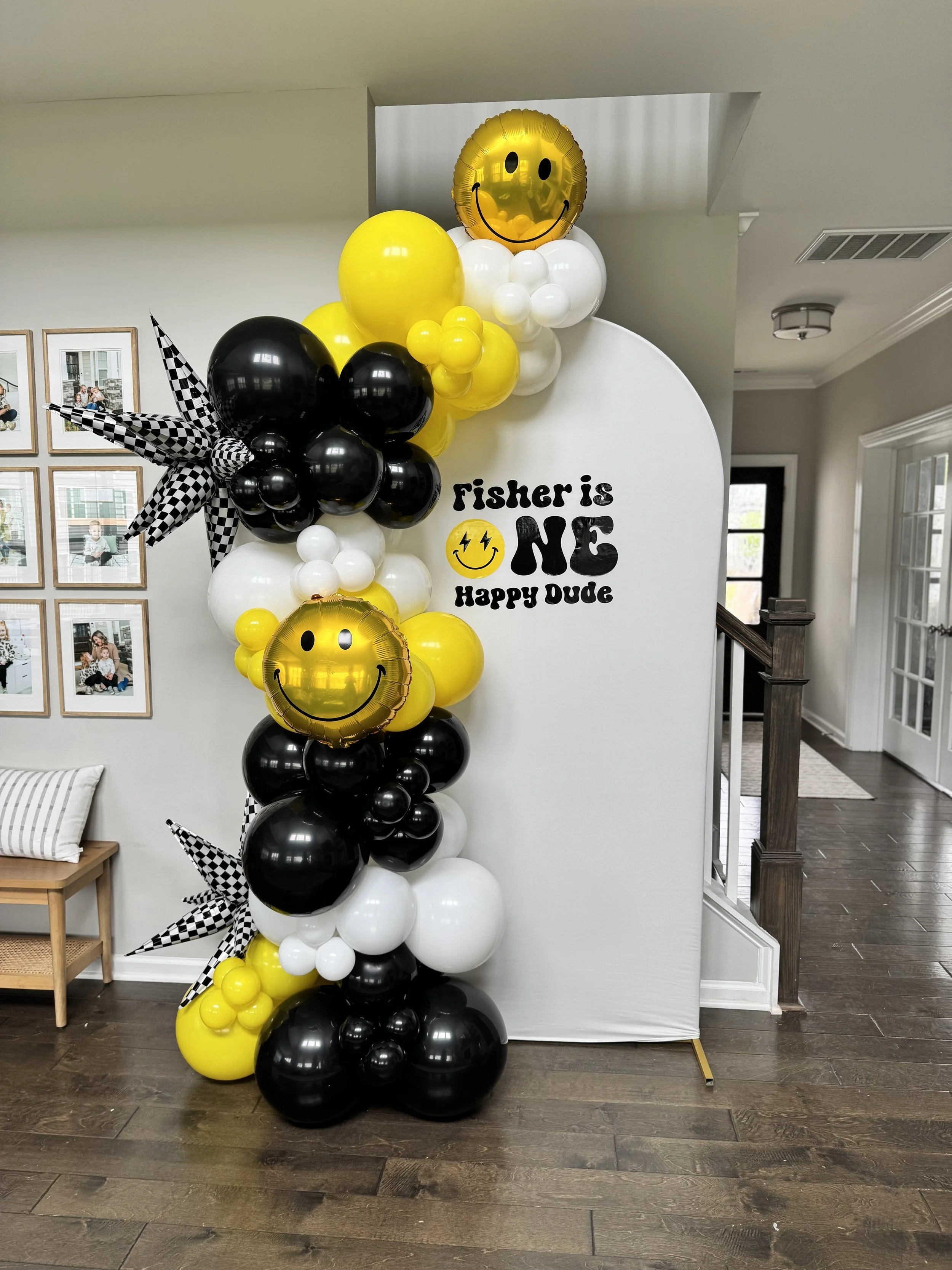 8-9ft deluxe garland attached to metal arch backdrop with fabric cover with custom vinyl decal on backdrop