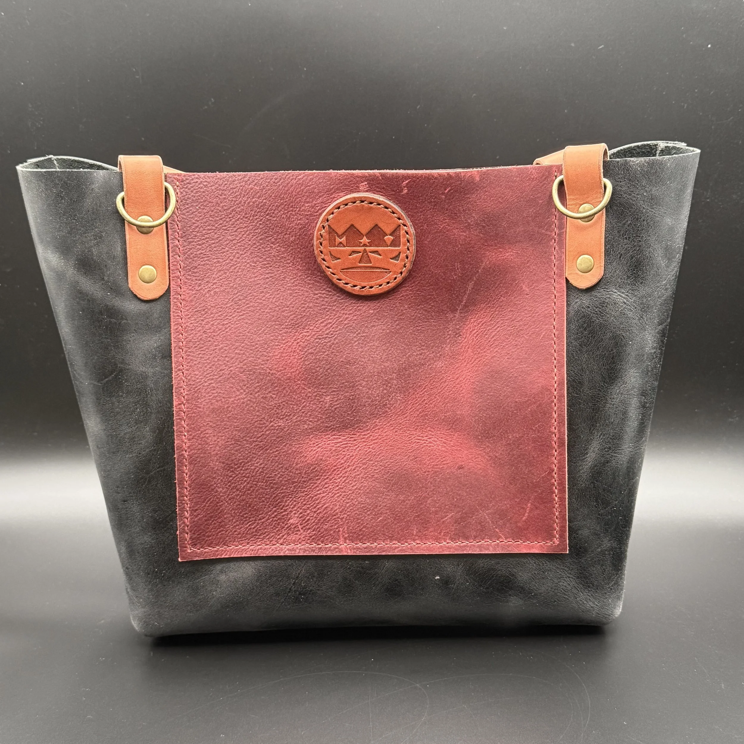 medium tote bag, black vegtan matt finish , 10"h x 10"w x 5"d, black cherry oil tanned leather front and back pockets 7"h x 7"w