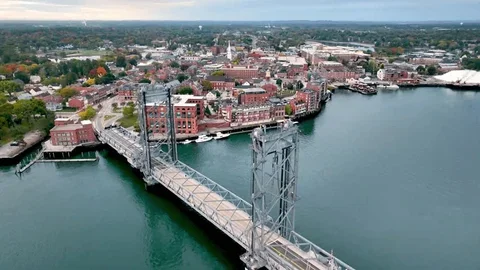Aerial view of a city with a river and a suspension bridge