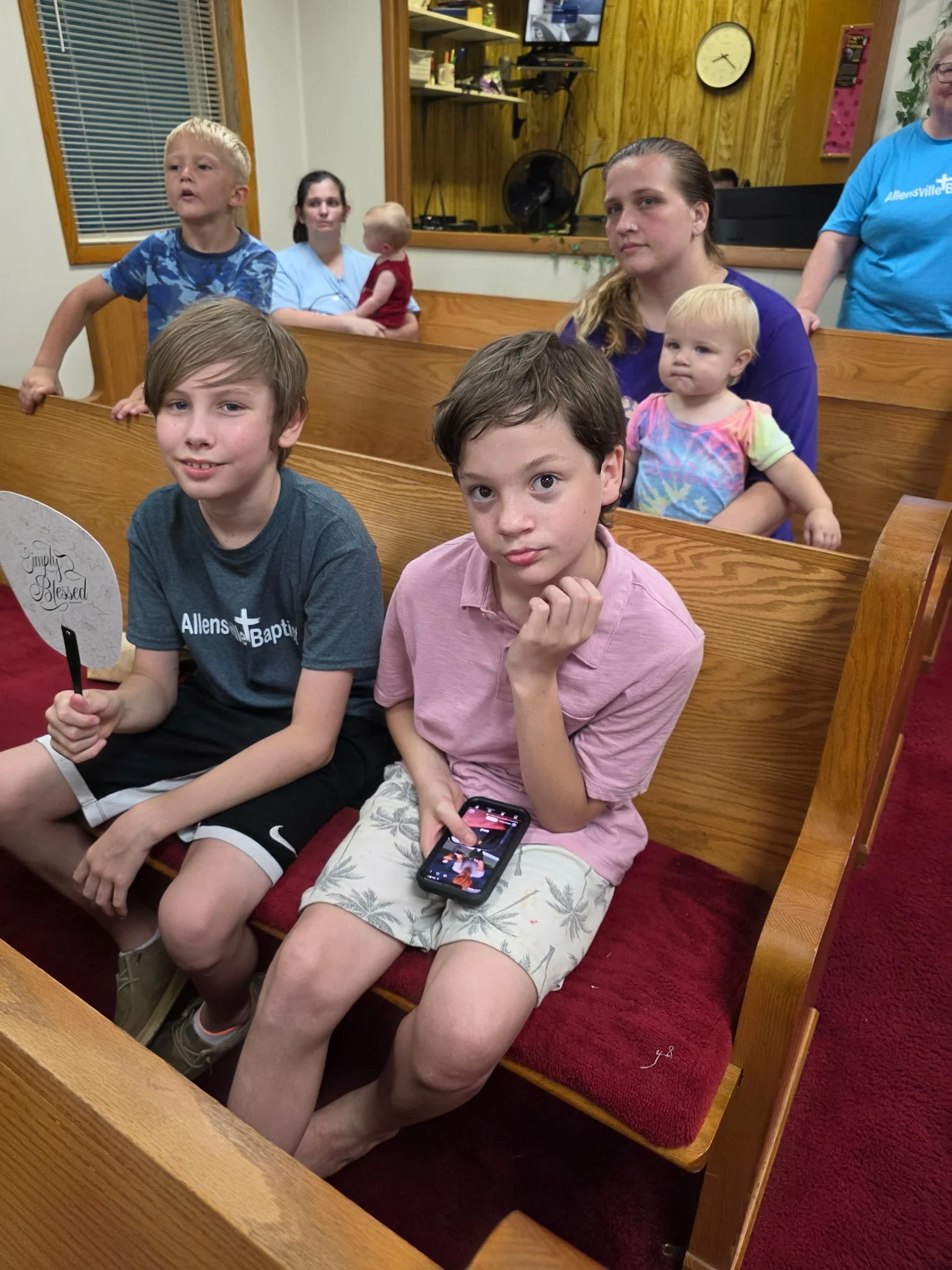 A group of children and adults seated in church pews during a Vacation Bible School.