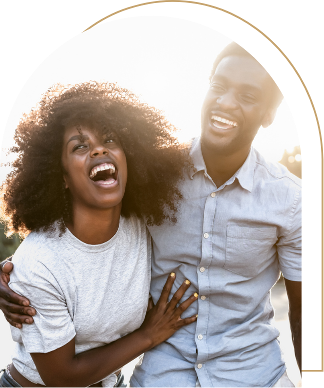 A man and woman laughing holding each other while walking on the beach | Kathleen Killen Psychotherapy and Coaching