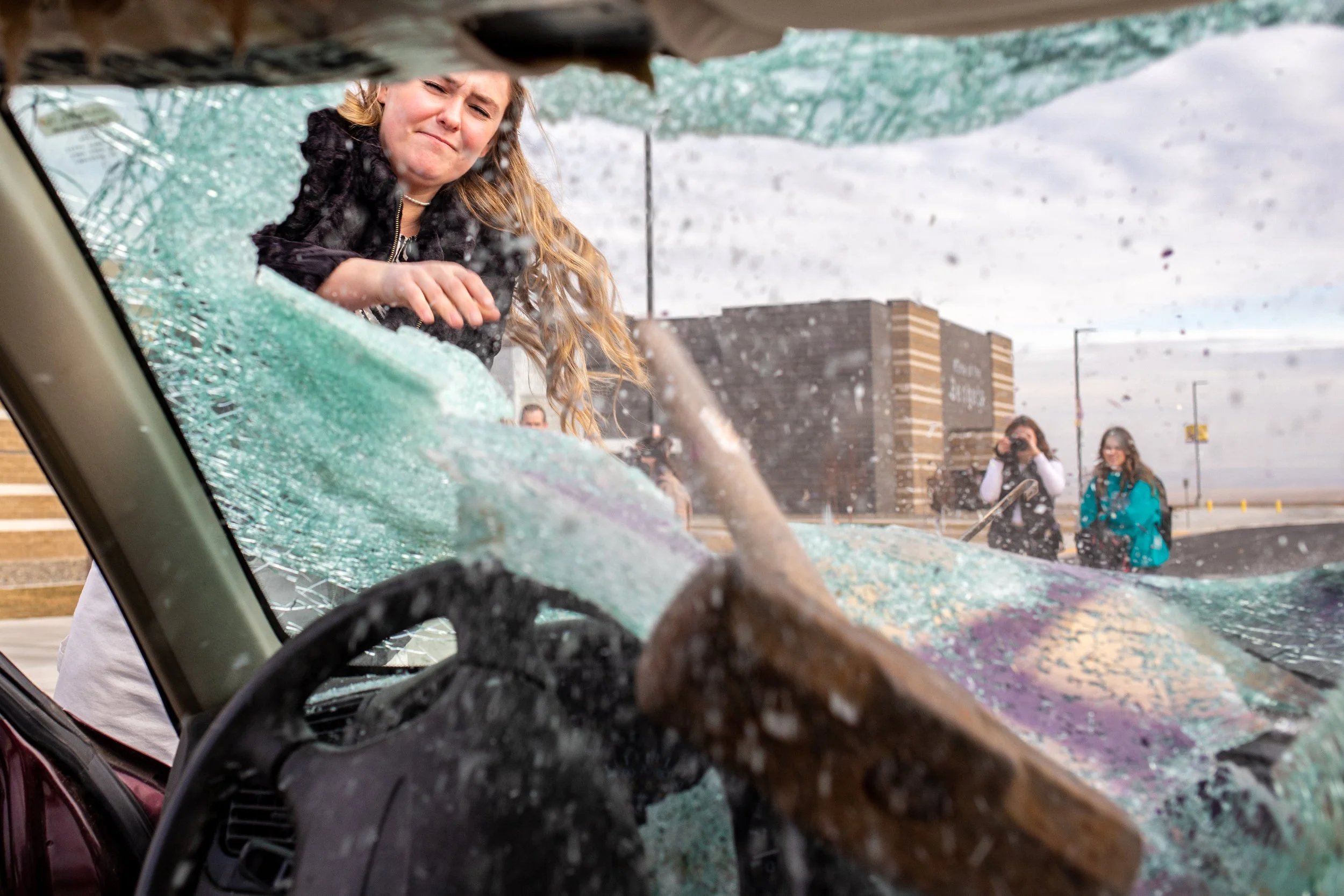 Lewiston High senior Annika Huff smashes through the front windshield of a car designated for destruction during a charity fundraising event at her high school Jan. 24, 2023, in Lewiston, Idaho.