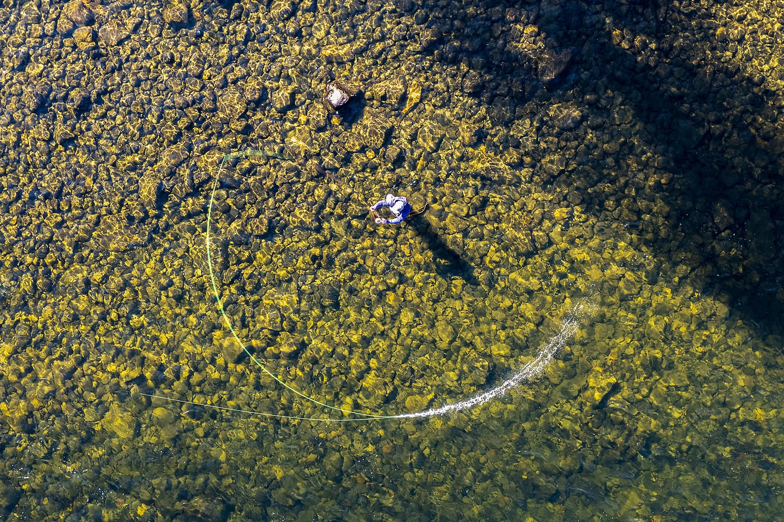 A fly fisherman stands waist deep in the Clearwater River as he casts his line into the slow moving current Oct. 18, 2022, near Orofino, Idaho.
