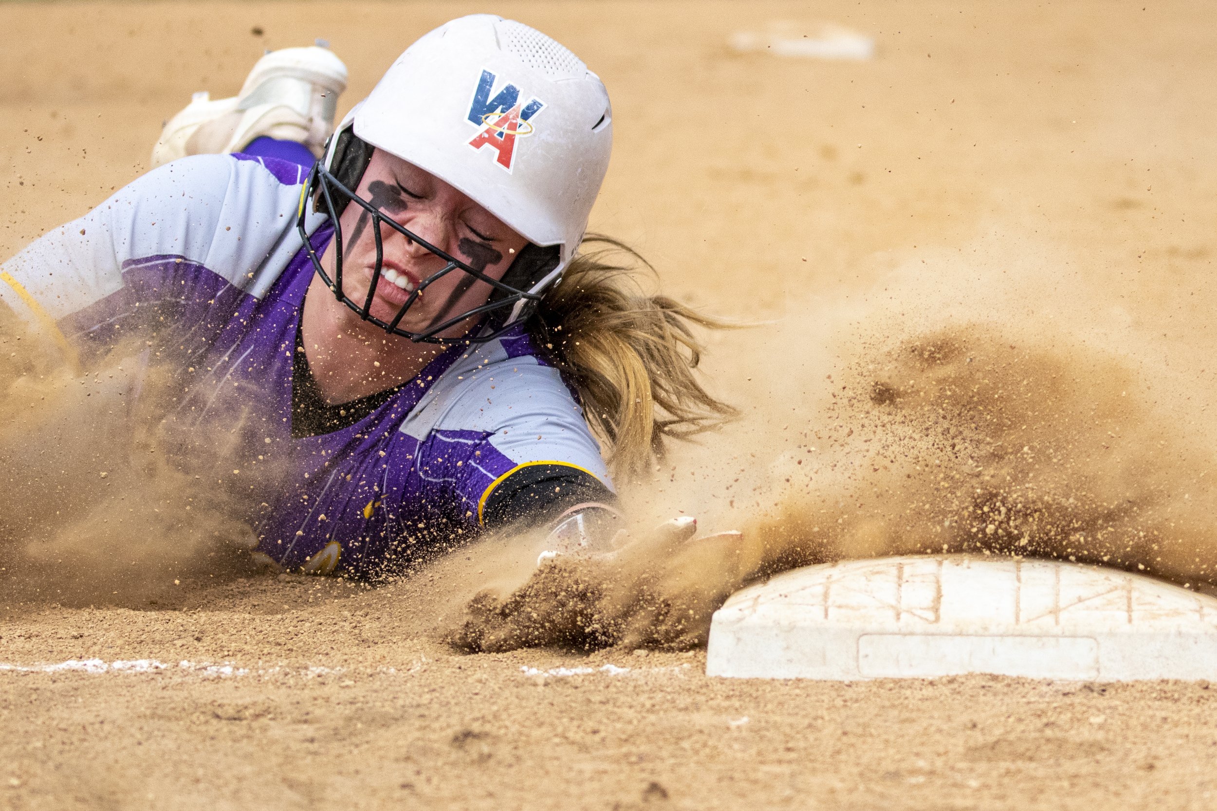 Lewiston High softball catcher Taryn Barney slides safely into third base during a double header against Coeur d’Alene at Airport Park March 22, 2022, in Lewiston, Idaho.