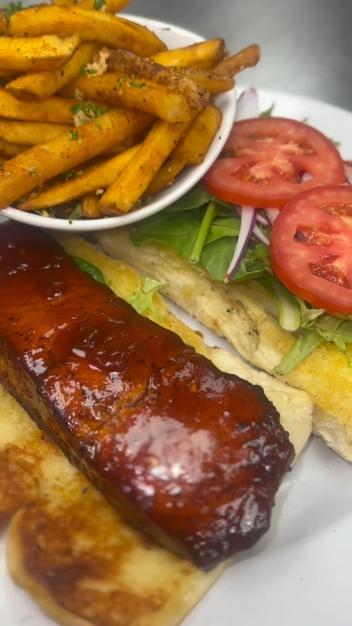 New special alert! 🚨Our BBQ Salmon Sandwich is packed with bold Caribbean flair and served with golden garlic fries on the side. Come get this delicious bite while it lasts!