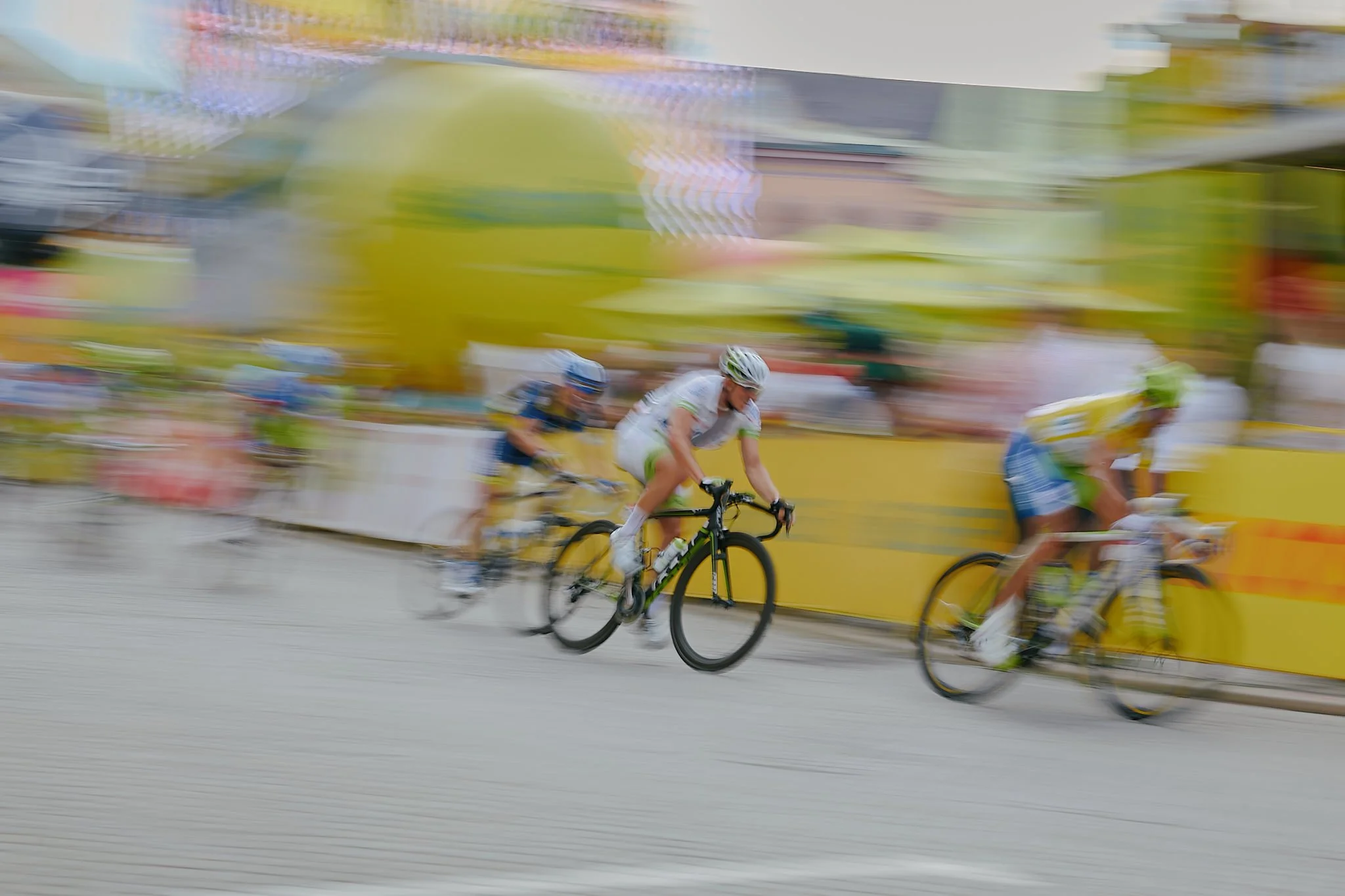 Cyclists competing in a race, with a blurred background indicating high speed.