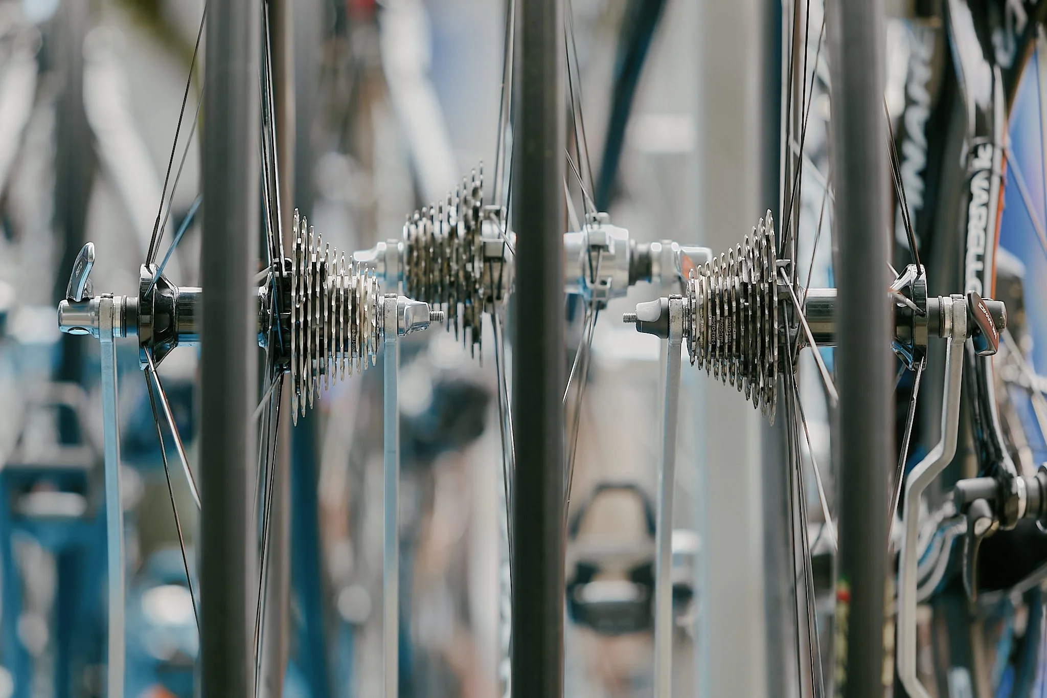 Close-up of a bicycle wheel hub with silver and black components, chain, and spokes, part of a bicycle on display.