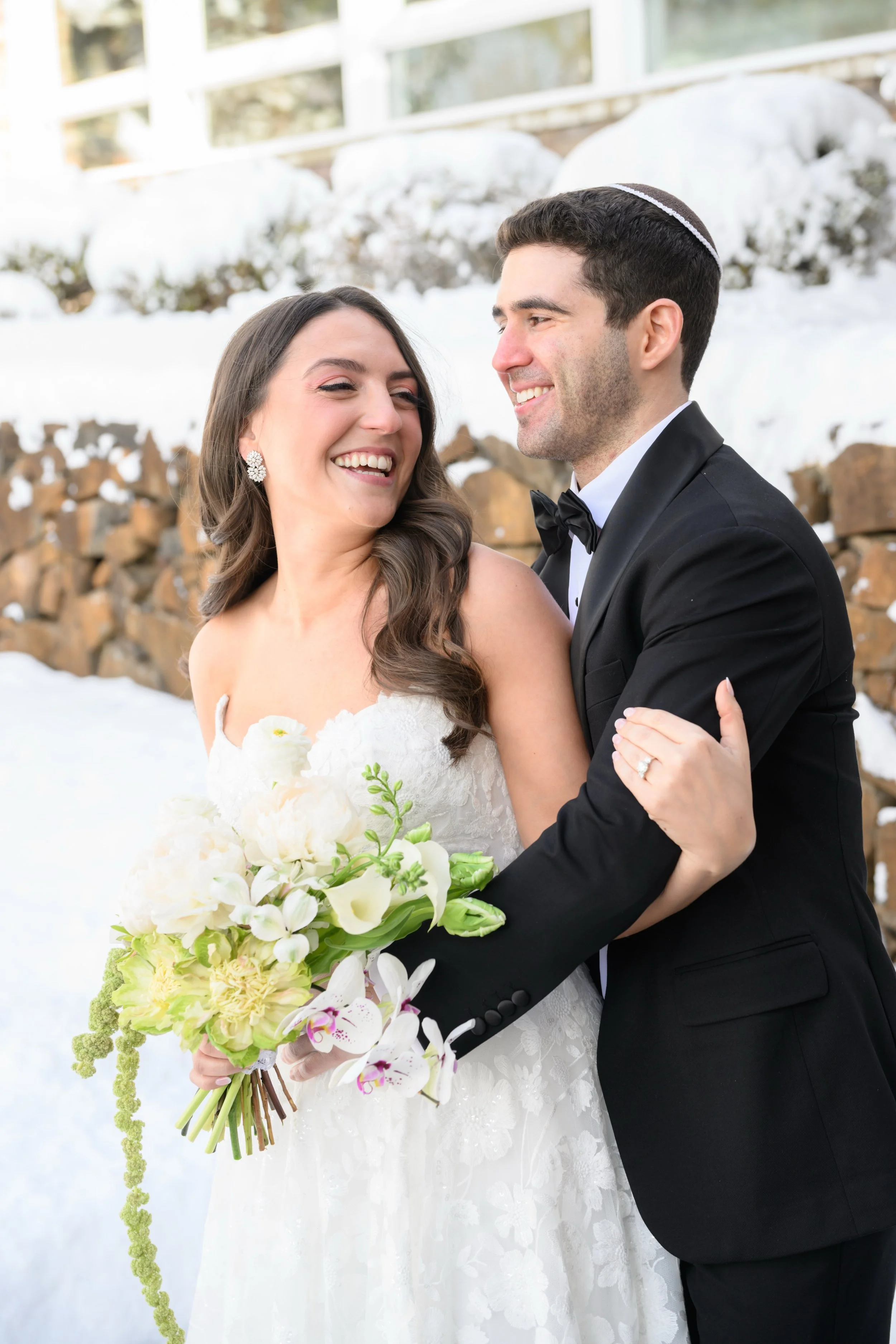 A couple beneath a garden-grown floral ceremony arch