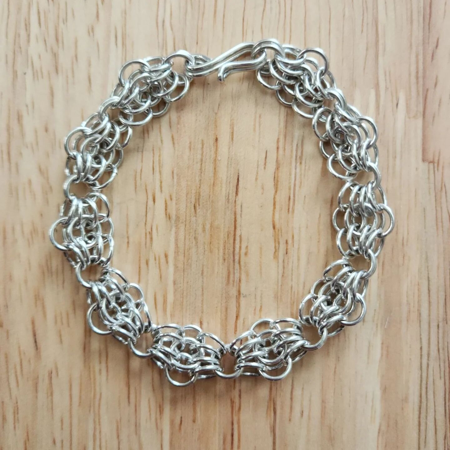 This is a beautiful statement piece that is silky on your wrist and good for fidgeting. This is a butterfly weave chain mail bracelet with a hook and eye clasp. The links are 18 gauge sterling silver and the clasp is made from 16 gauge sterling silve
