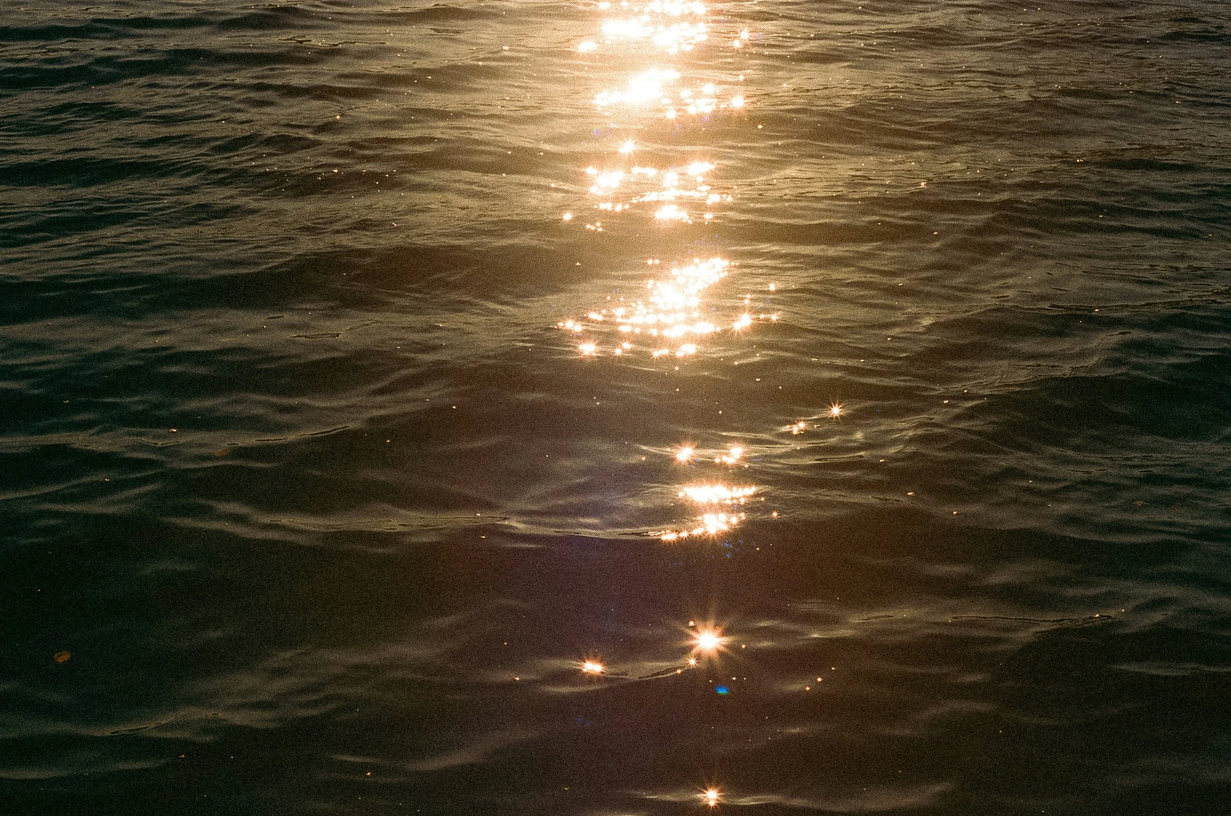 Shimmering light across moving water reflecting immersive group breathwork and somatic release