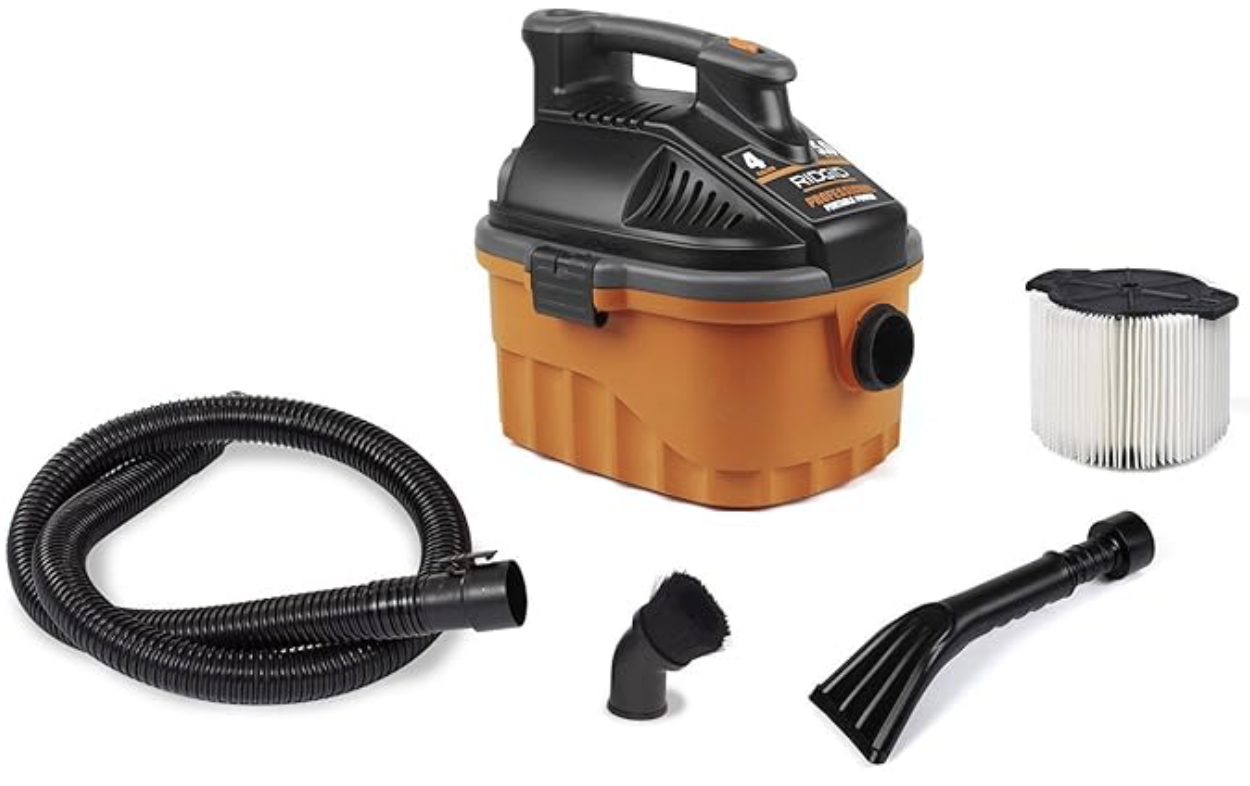 Wet/dry vacuum cleaner with black and orange body, hose, filter, and various attachments.