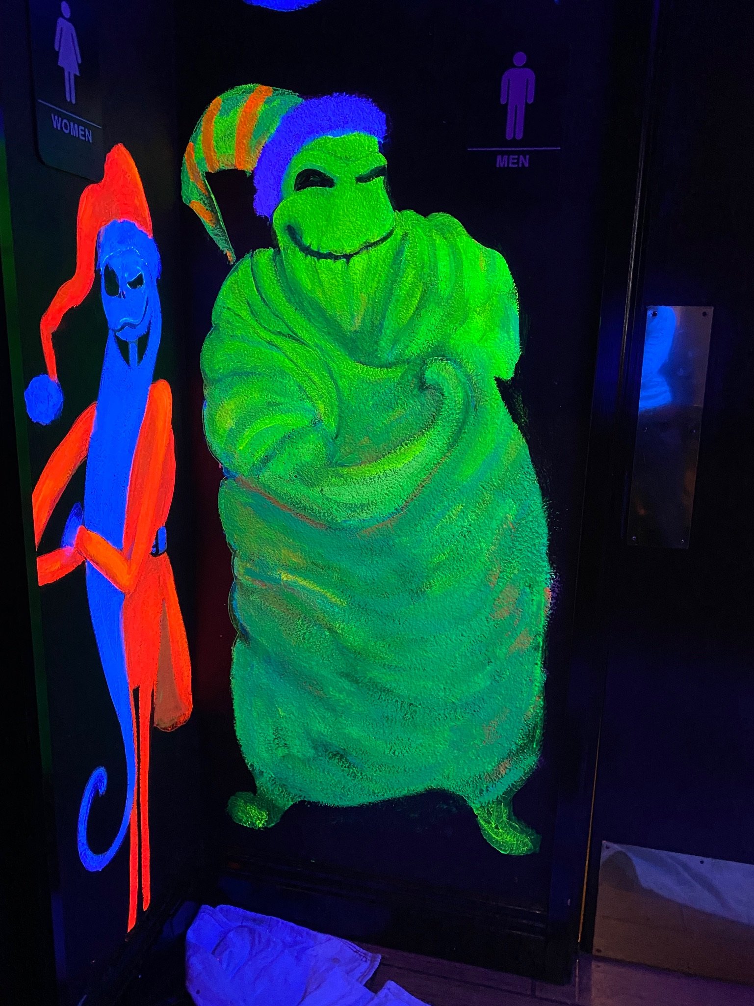 A Glow in The
Dark mural on the bathroom doors of a bar