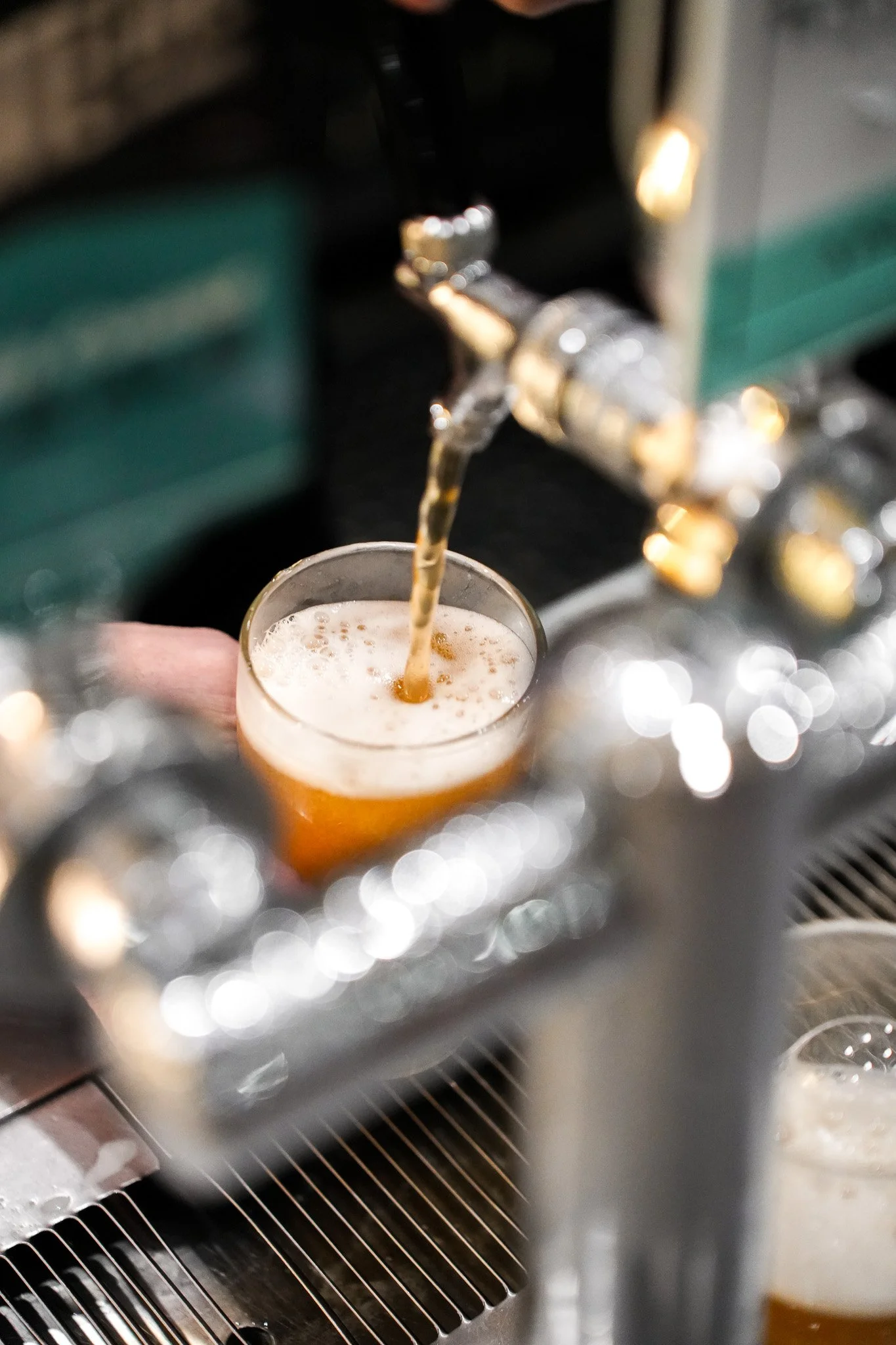 Draft beer being poured from a tap into a glass.