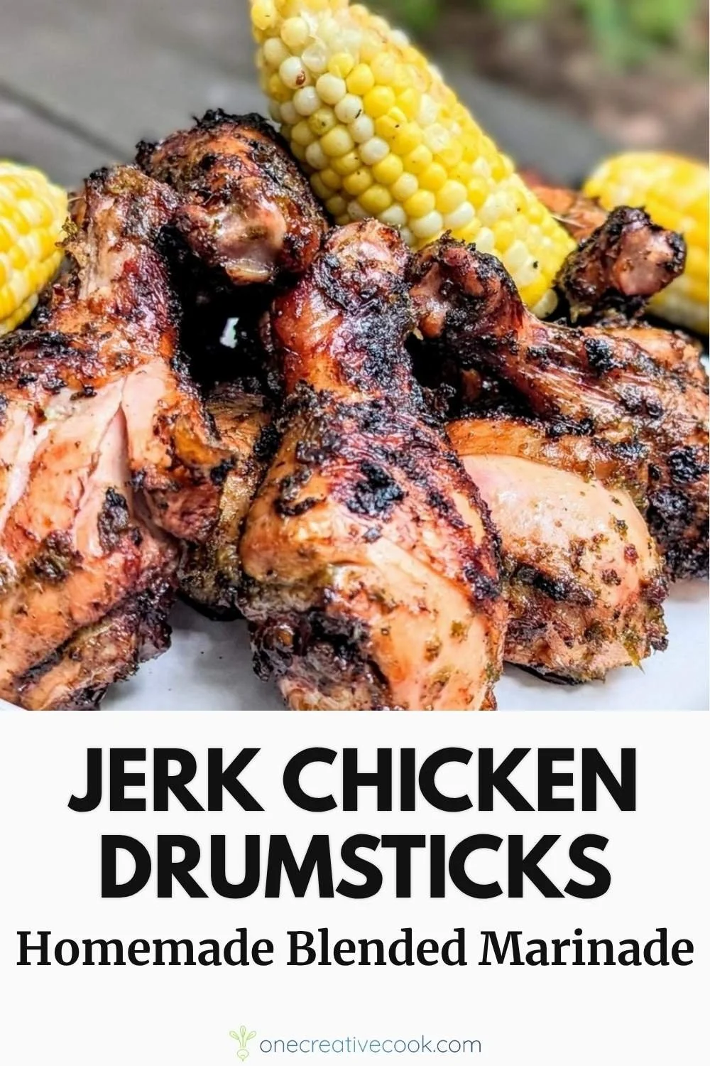 Fire grilled jerk chicken drumsticks served with corn on a camping table