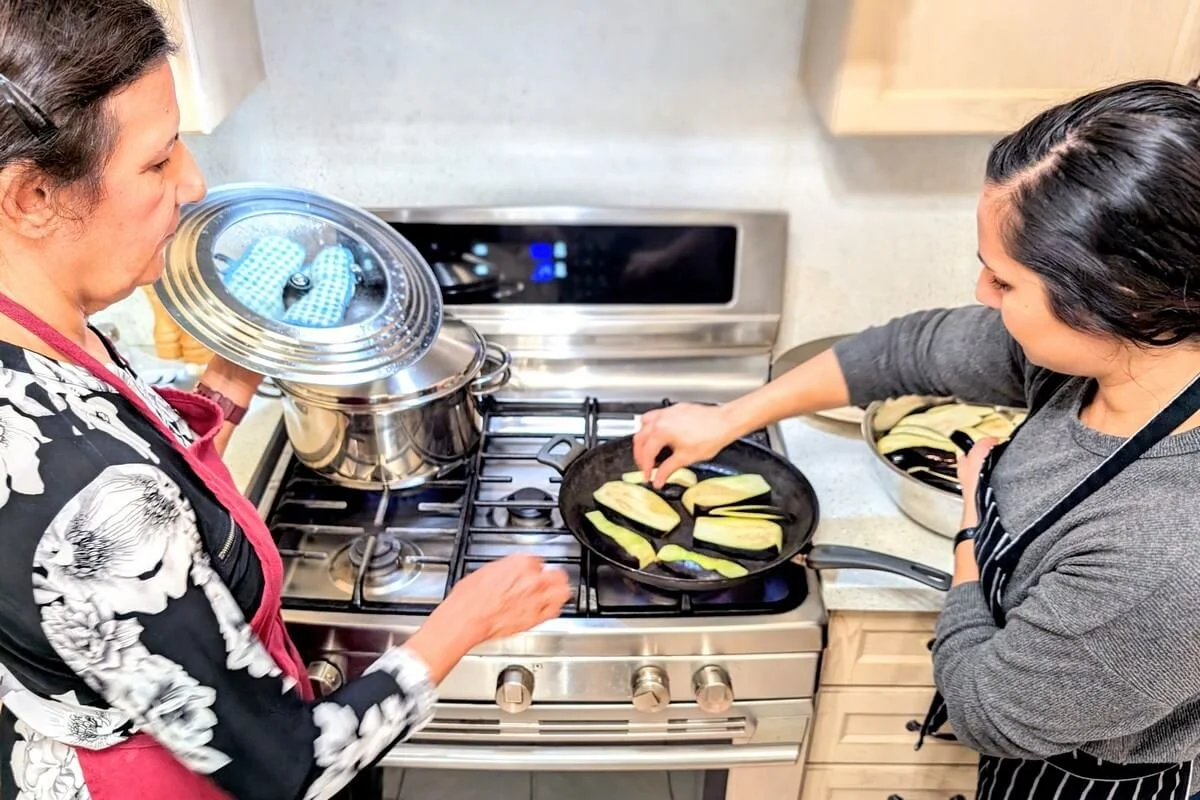 Chef Reem cooking eggplant with her mother for traditional Iraqi lamb and eggplant stew