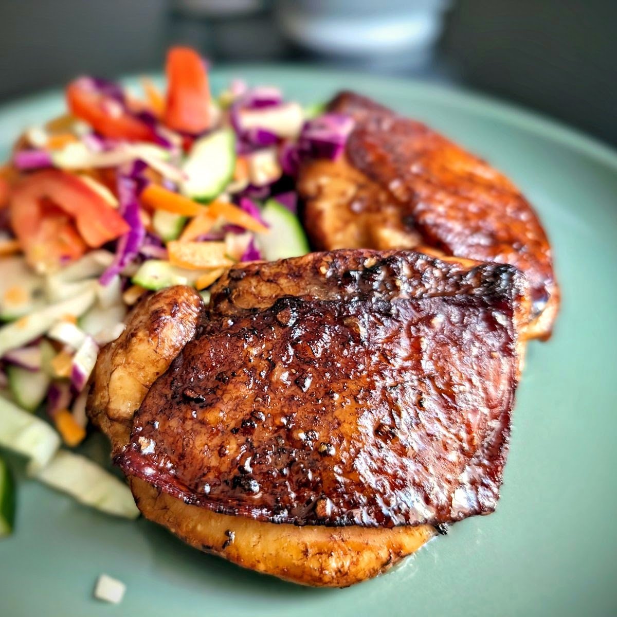 Air fryer balsamic chicken thighs with glossy caramelized glaze served with fresh cabbage and cucumber slaw
