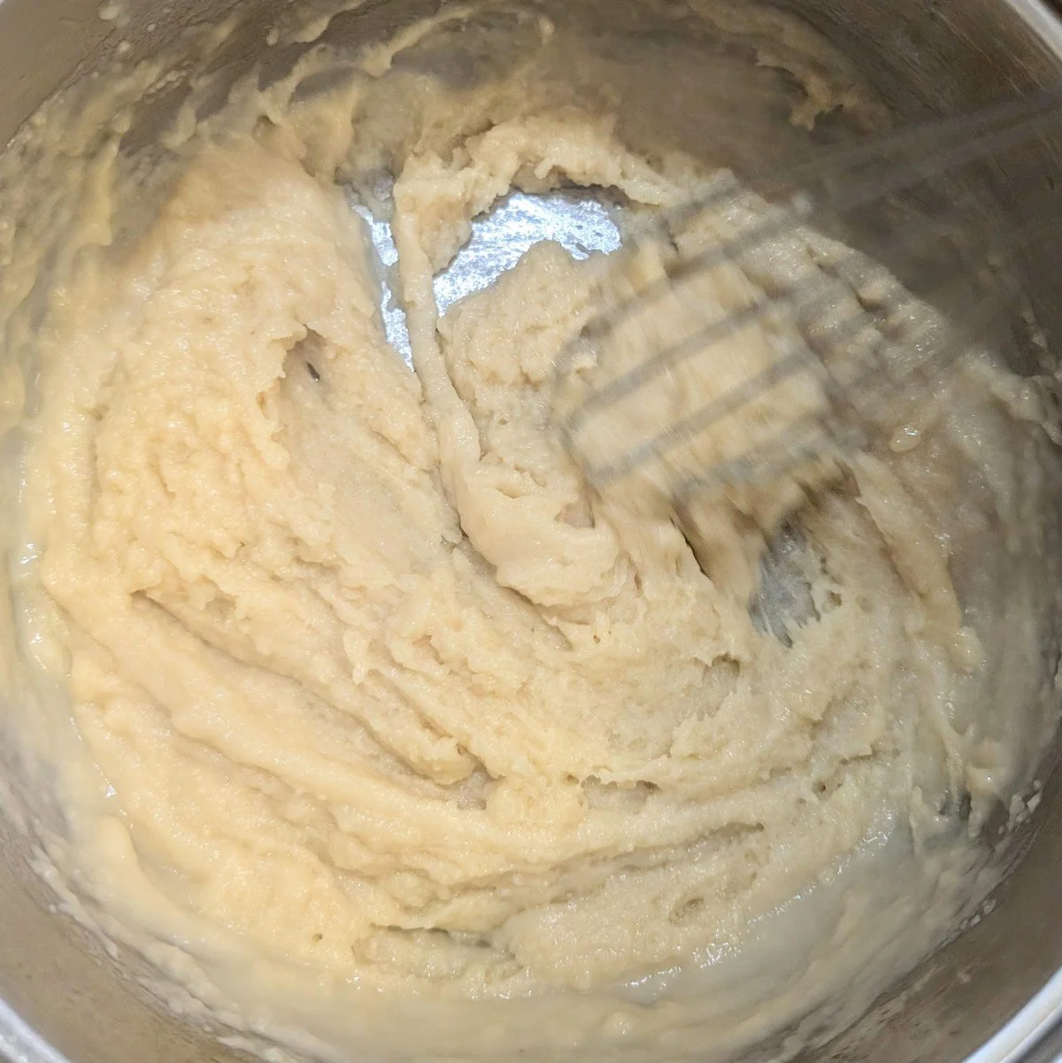 Veloute sauce being whisked and is very thick at first