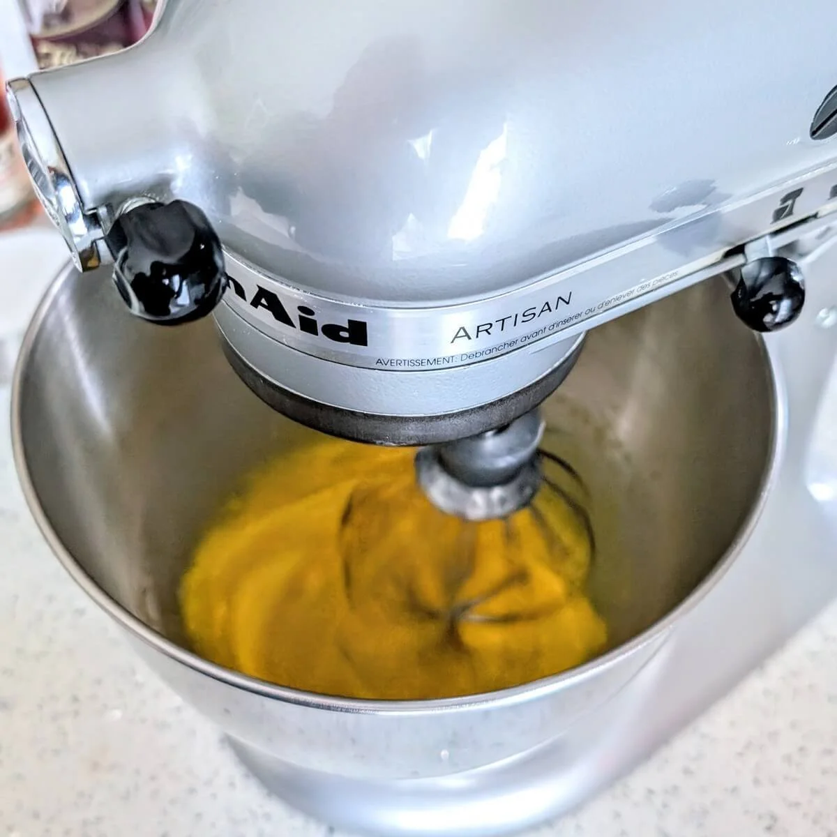 Whipping eggs in a stand mixer to make homemade aged eggnog