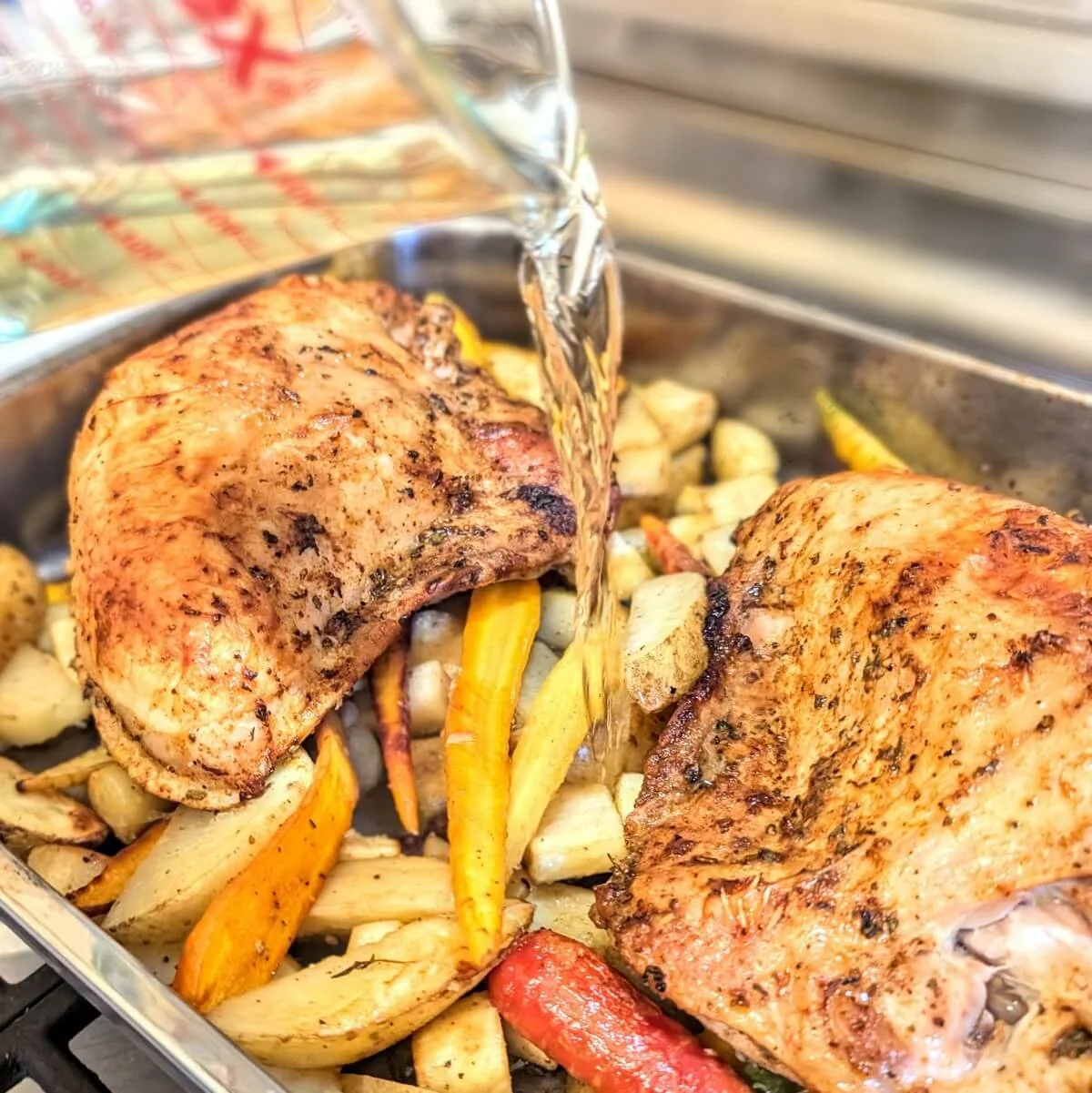 Adding white wine to the roasting pan with the turkey breast and vegetables