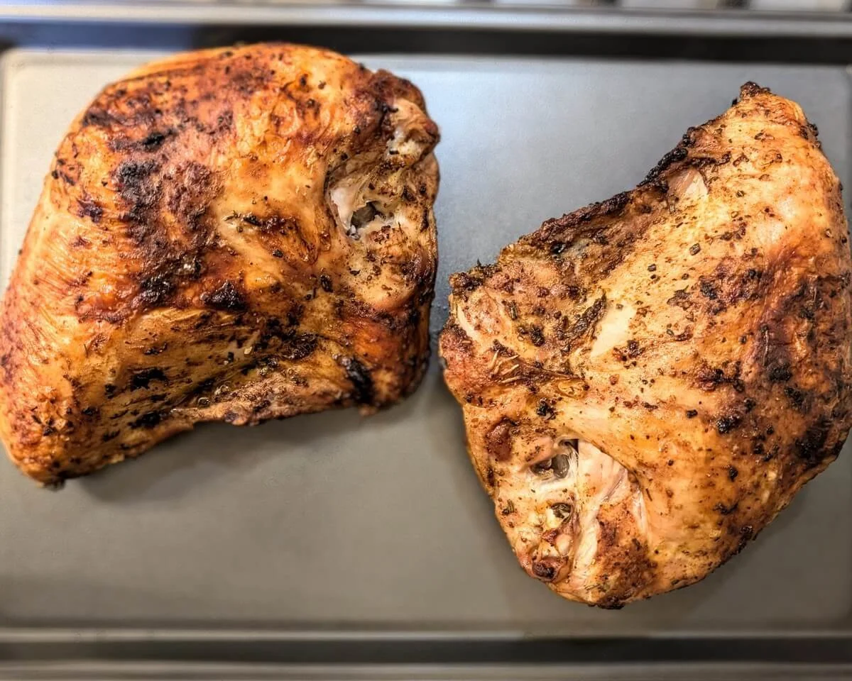 Rested roasted turkey breasts on a tray after cooking