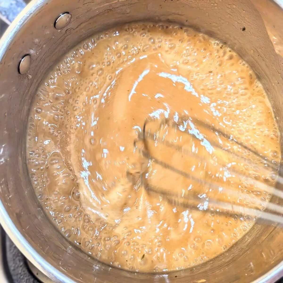 Whisking the finished gravy for Thanksgiving turkey breast dinner