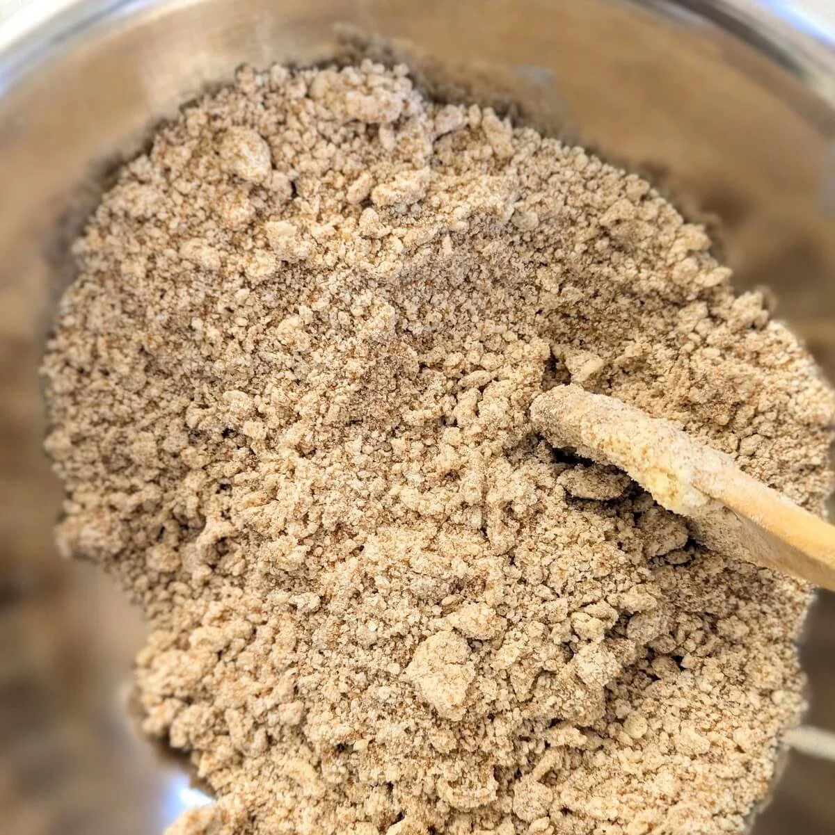 Mixing cookie dough base for sea salt dark chocolate chunk cookies with a wooden spoon