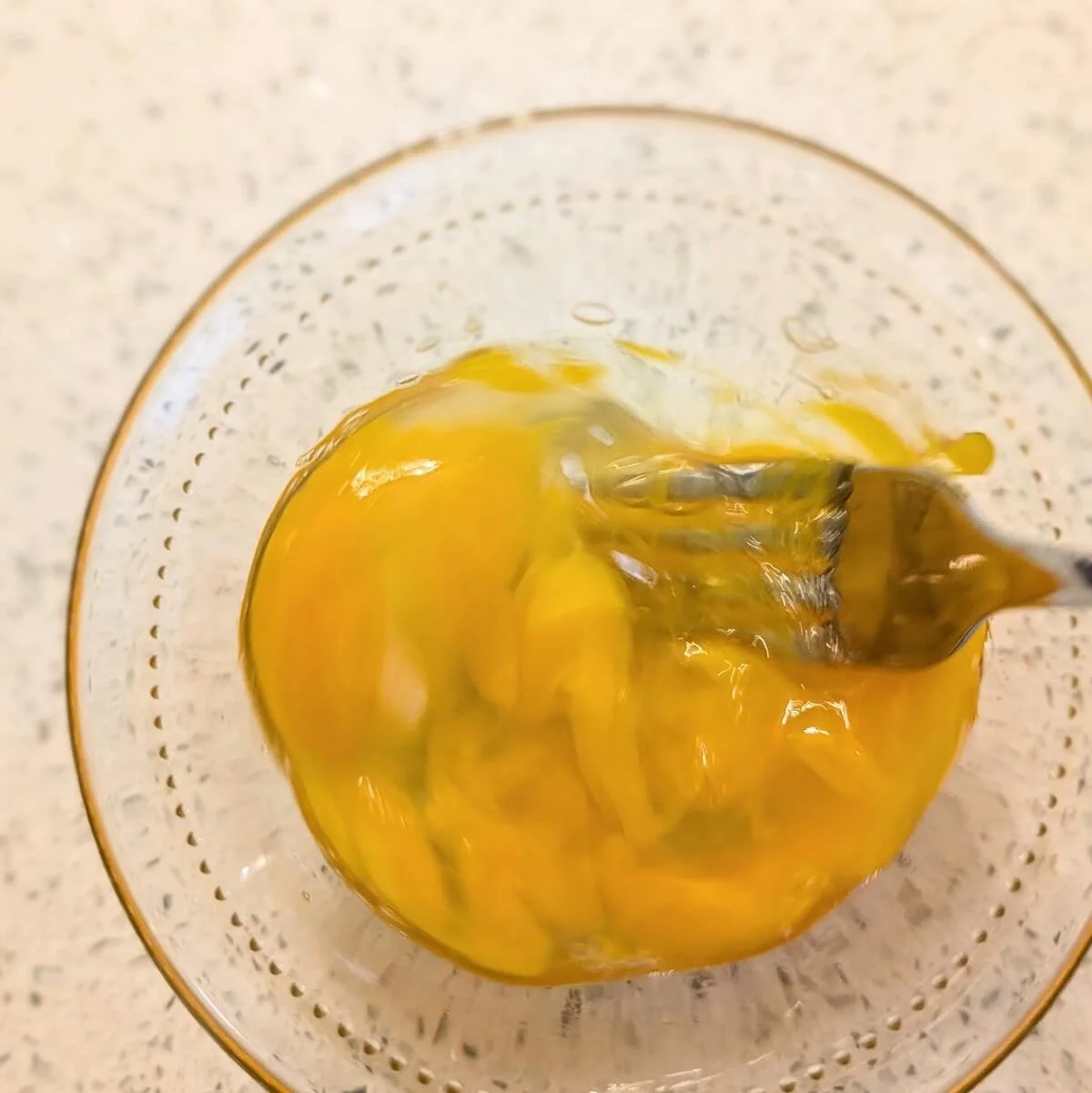 Whisking an egg in a small bowl for salted chocolate chip cookie dough