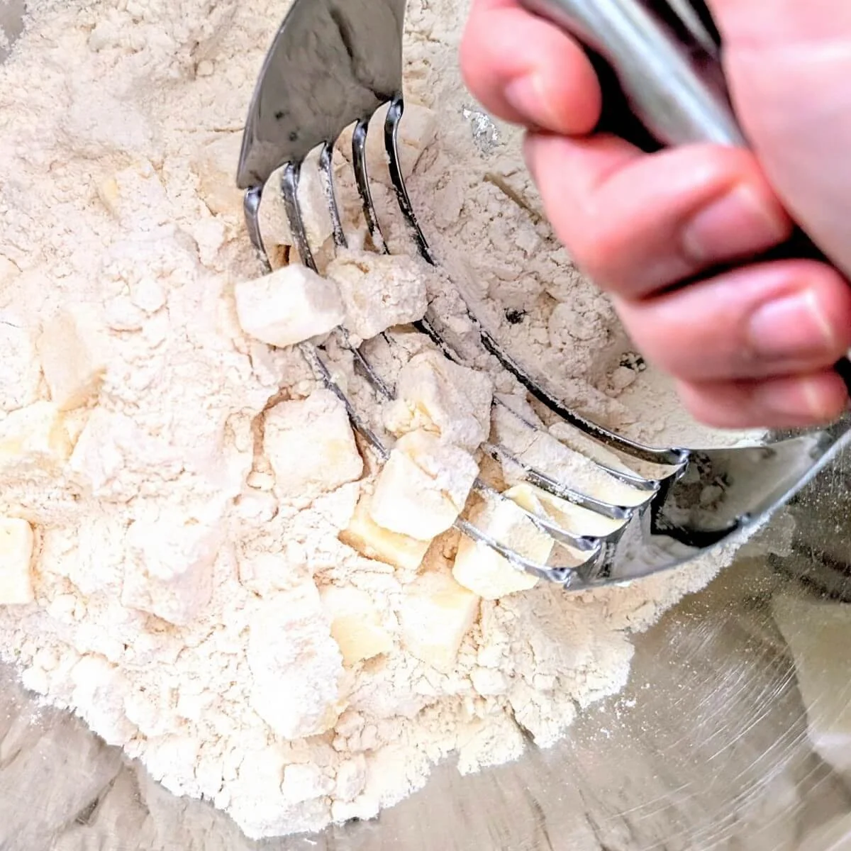 Cutting cold butter into flour for a homemade pumpkin pie crust
