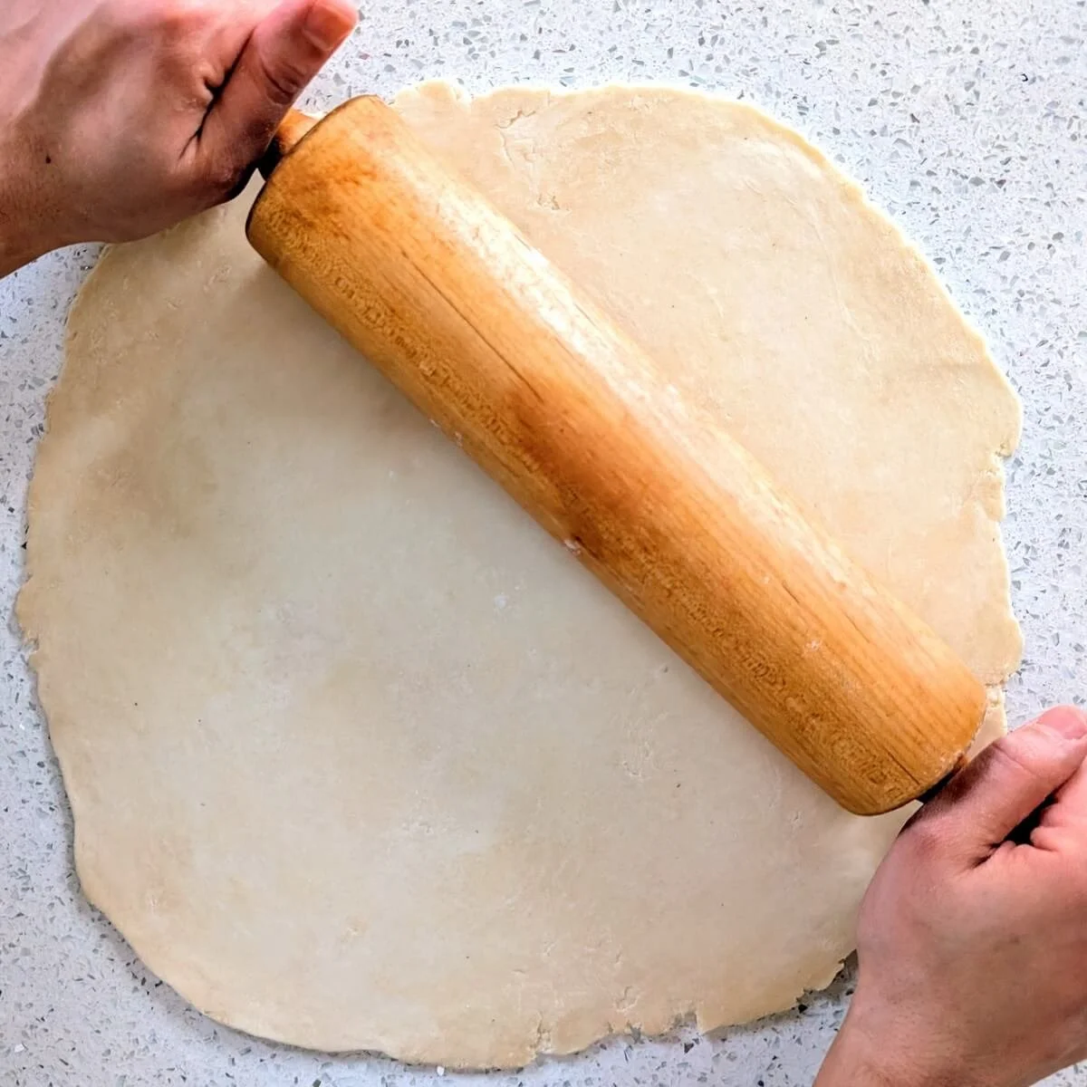 Rolling out pie dough into a circle for classic pumpkin pie from scratch