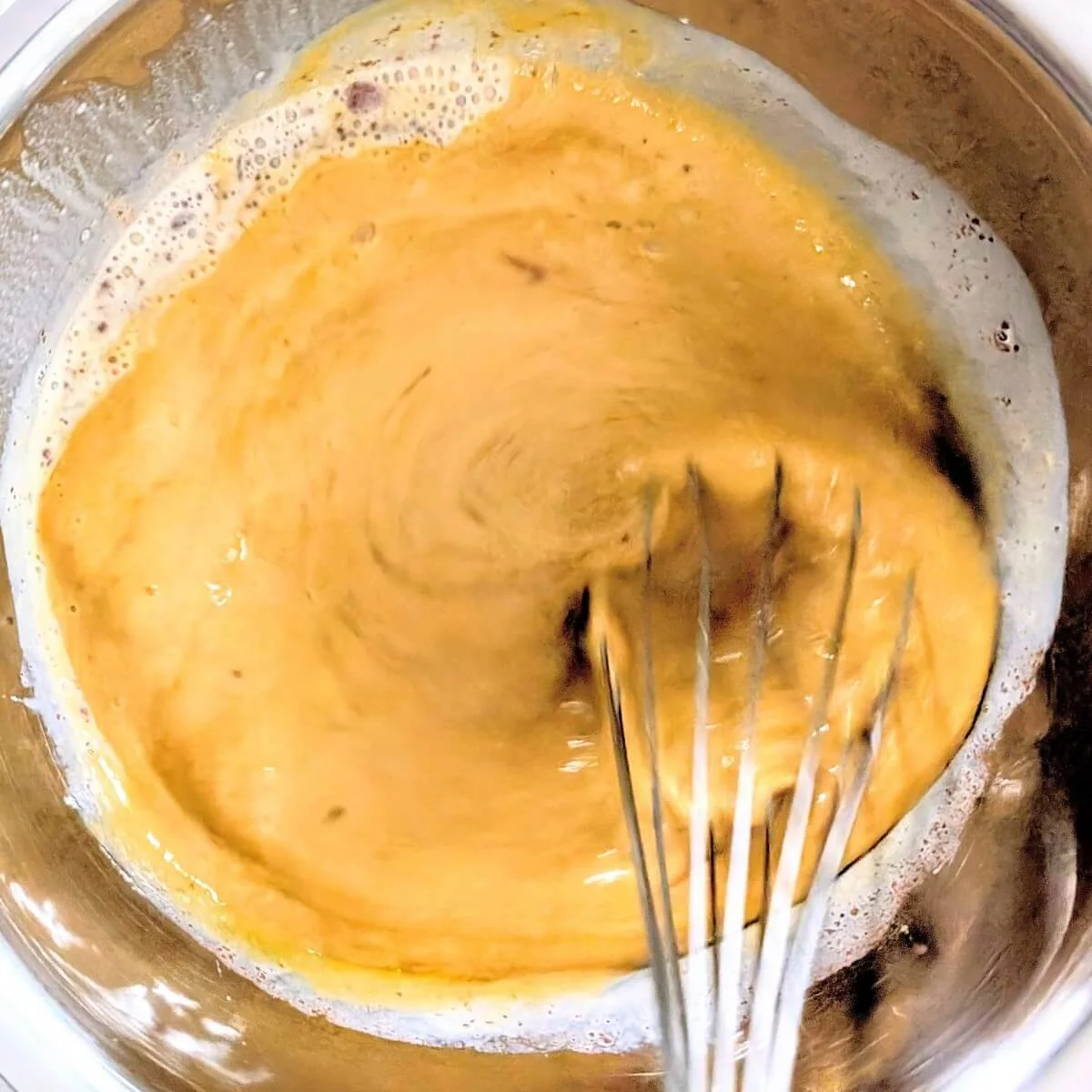 Homemade pumpkin pie filling being whisked in a bowl