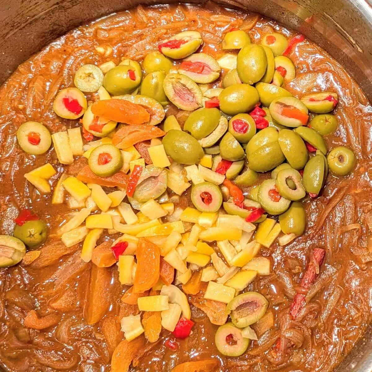 Sliced green olives, dried apricots, and chopped preserved lemon peel added to make Moroccan apricot chicken tagine