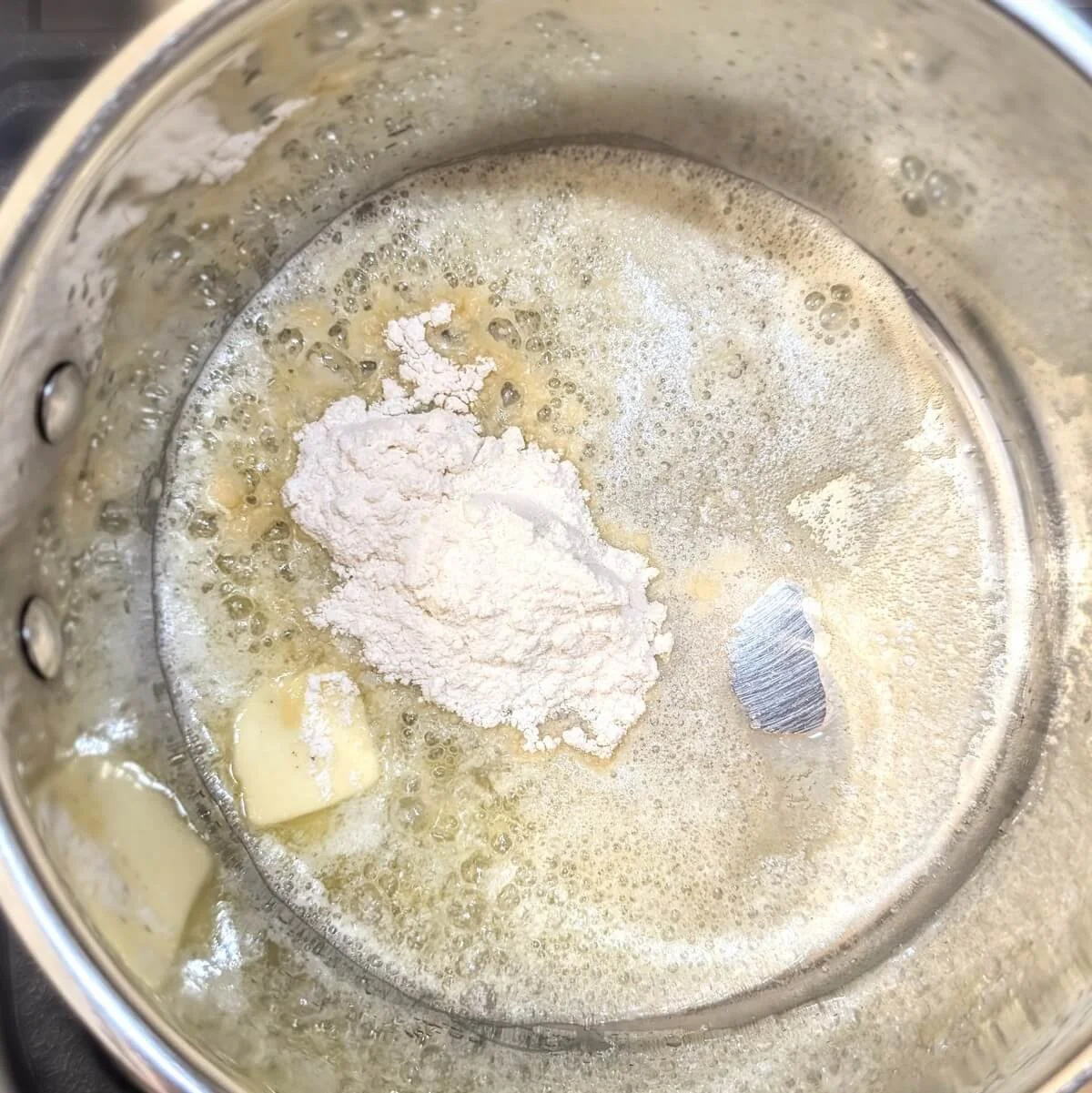 Flour and butter cooking in a pan, used to make roux to thicken béchamel and other French mother sauces