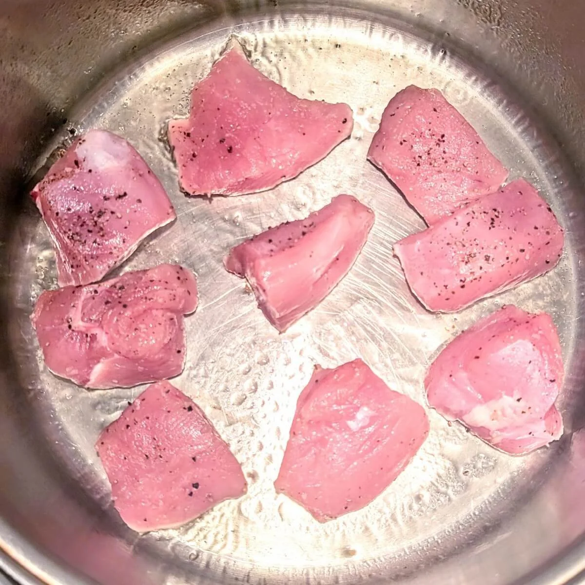 Seasoned turkey breast searing a pot to make turkey cacciatore
